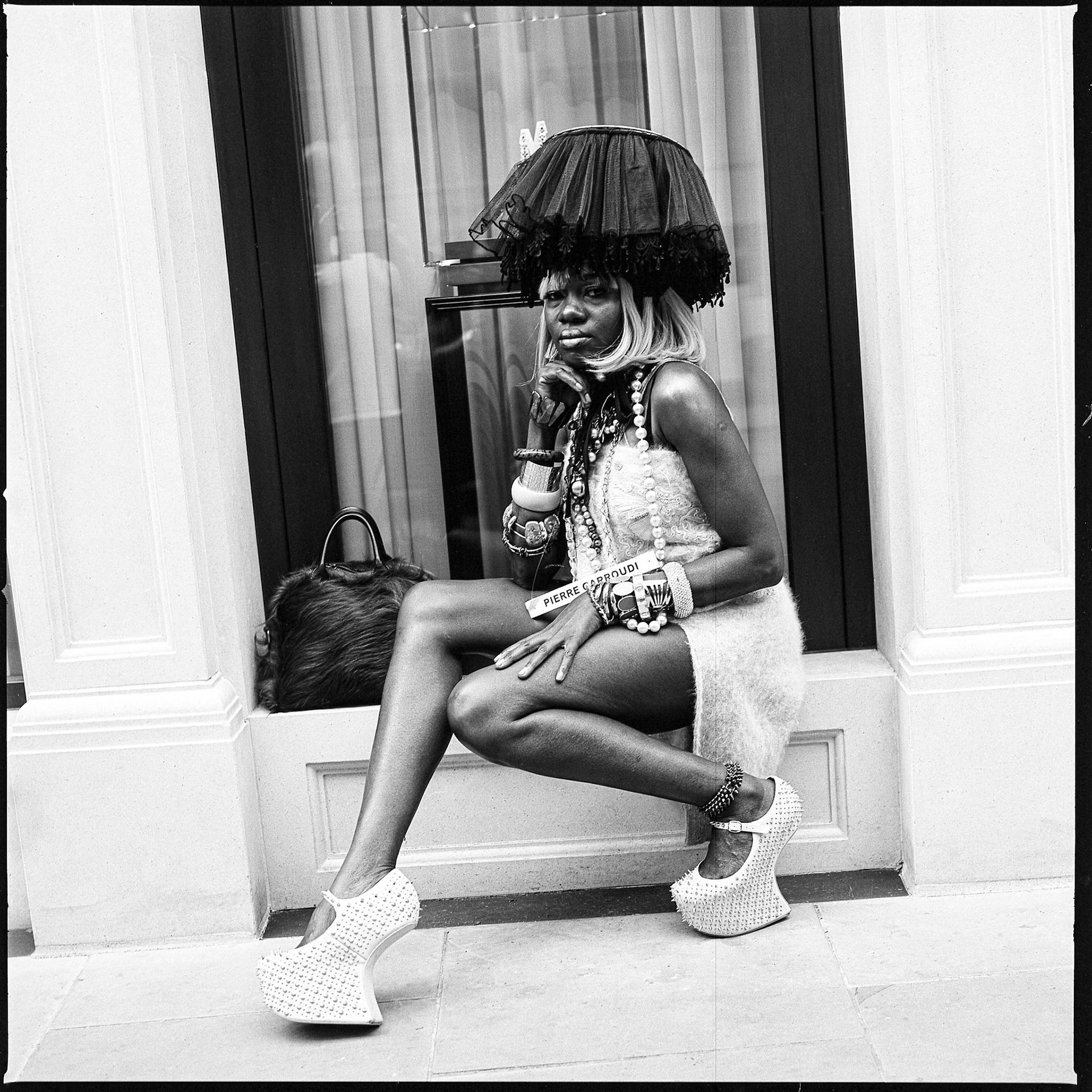 A model dressed and styled by Pierre Garroudi sits on a Bond St window ledge. Shot on film in B&W