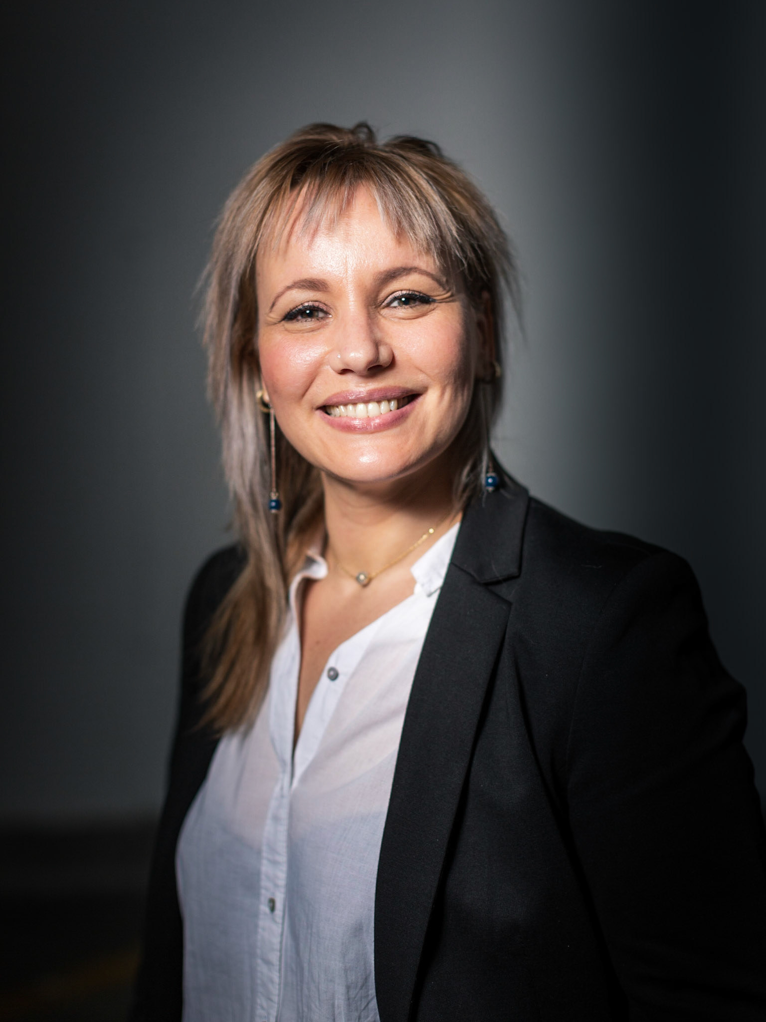 A 3/4 portrait of a confident smiling professional woman.