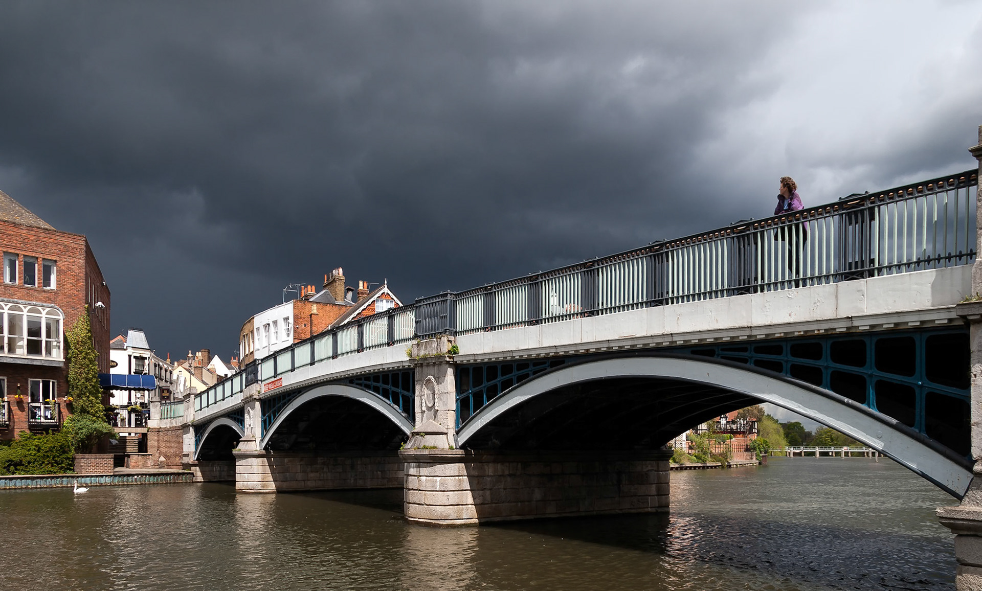 WINDSOR, BERKSHIRE/UK - APRIL 27 : Woman looking over Eton bridge as a storm approaches in Windsor on April 27, 2005. Unidentified woman.