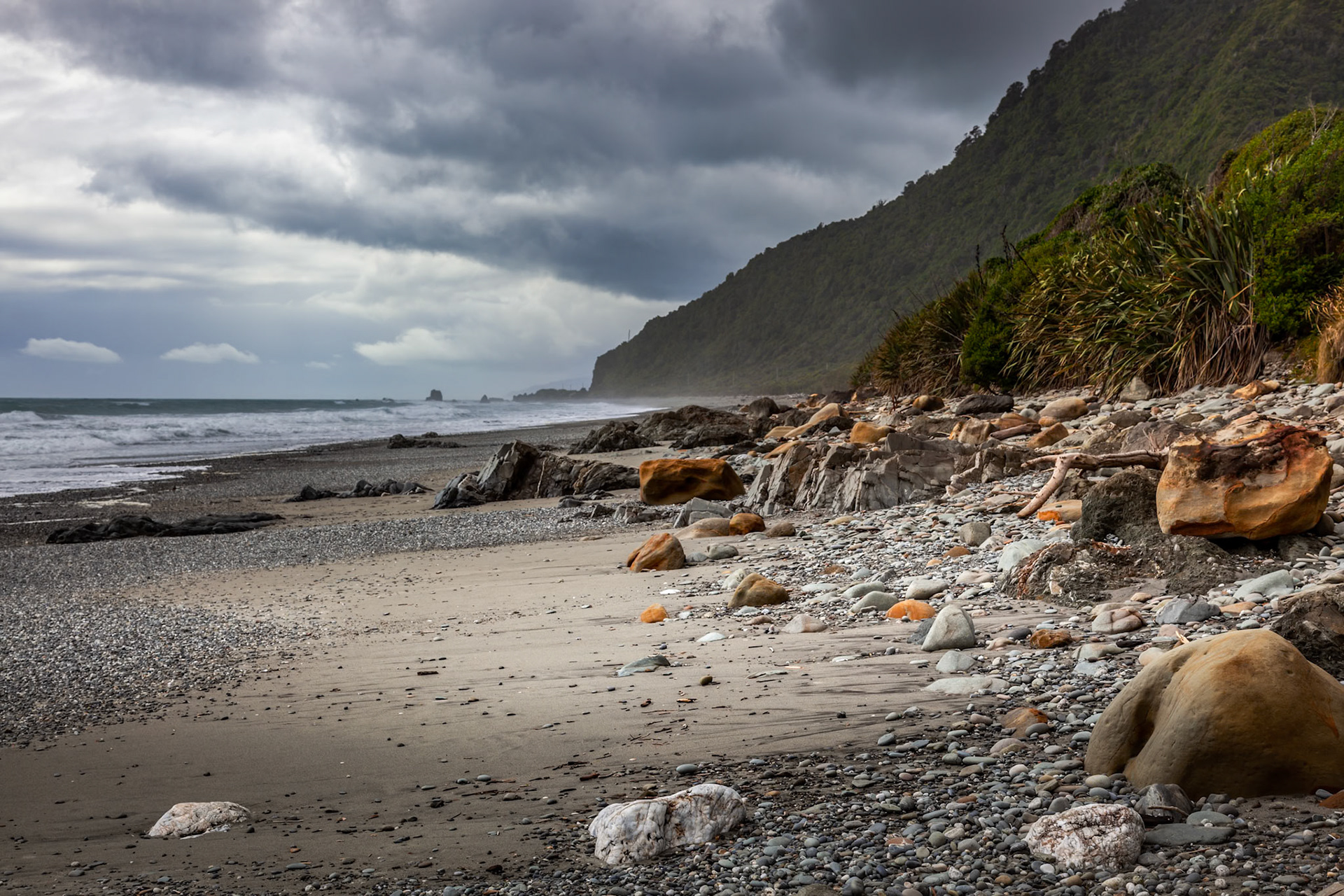 Stormy weather approaching a rock strewn beach in New Zealand