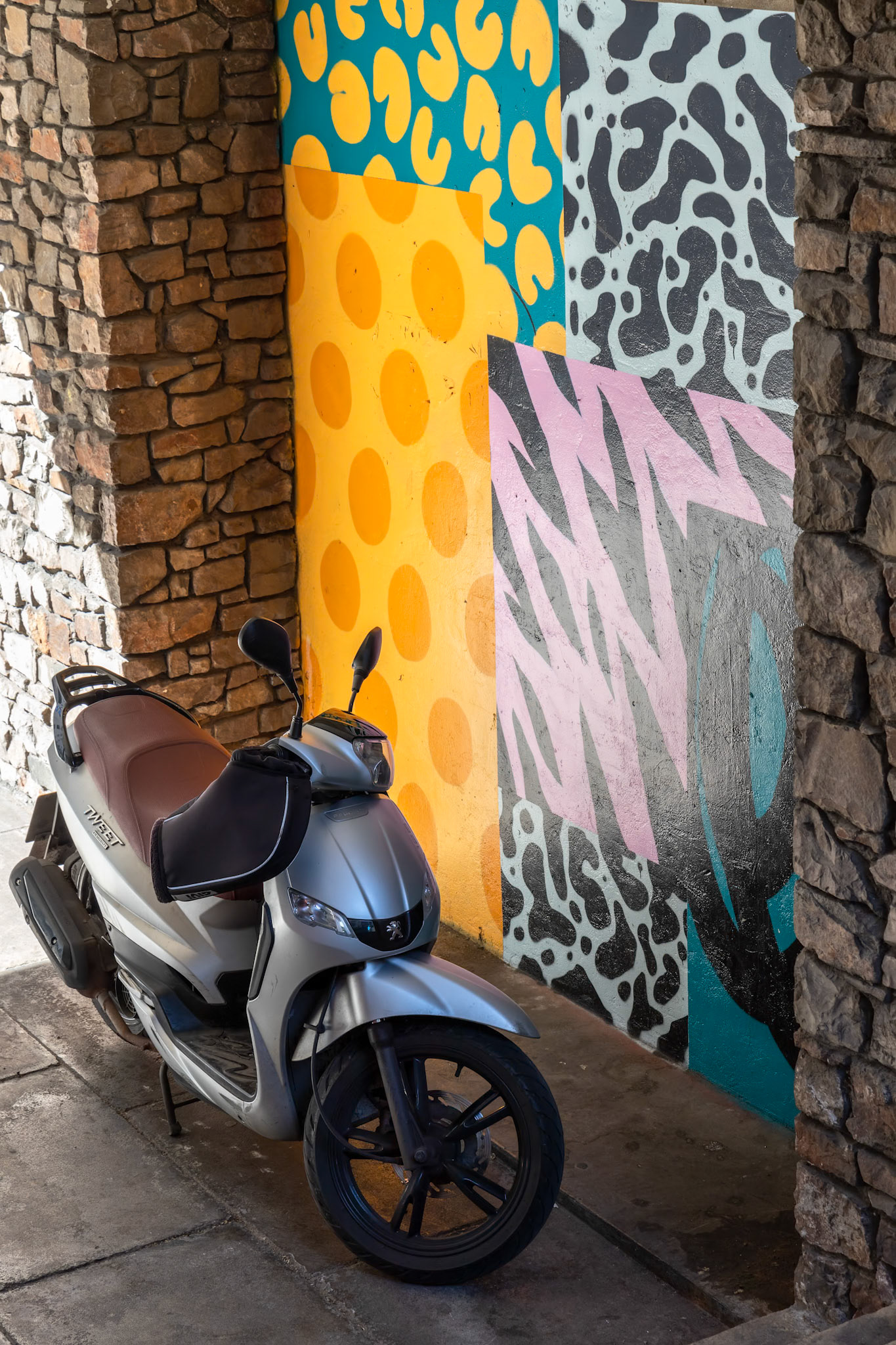 BRISTOL, UK - MAY 14 : Small motorcycle parked in an alley with decorated walls in Bristol on May 14, 2019