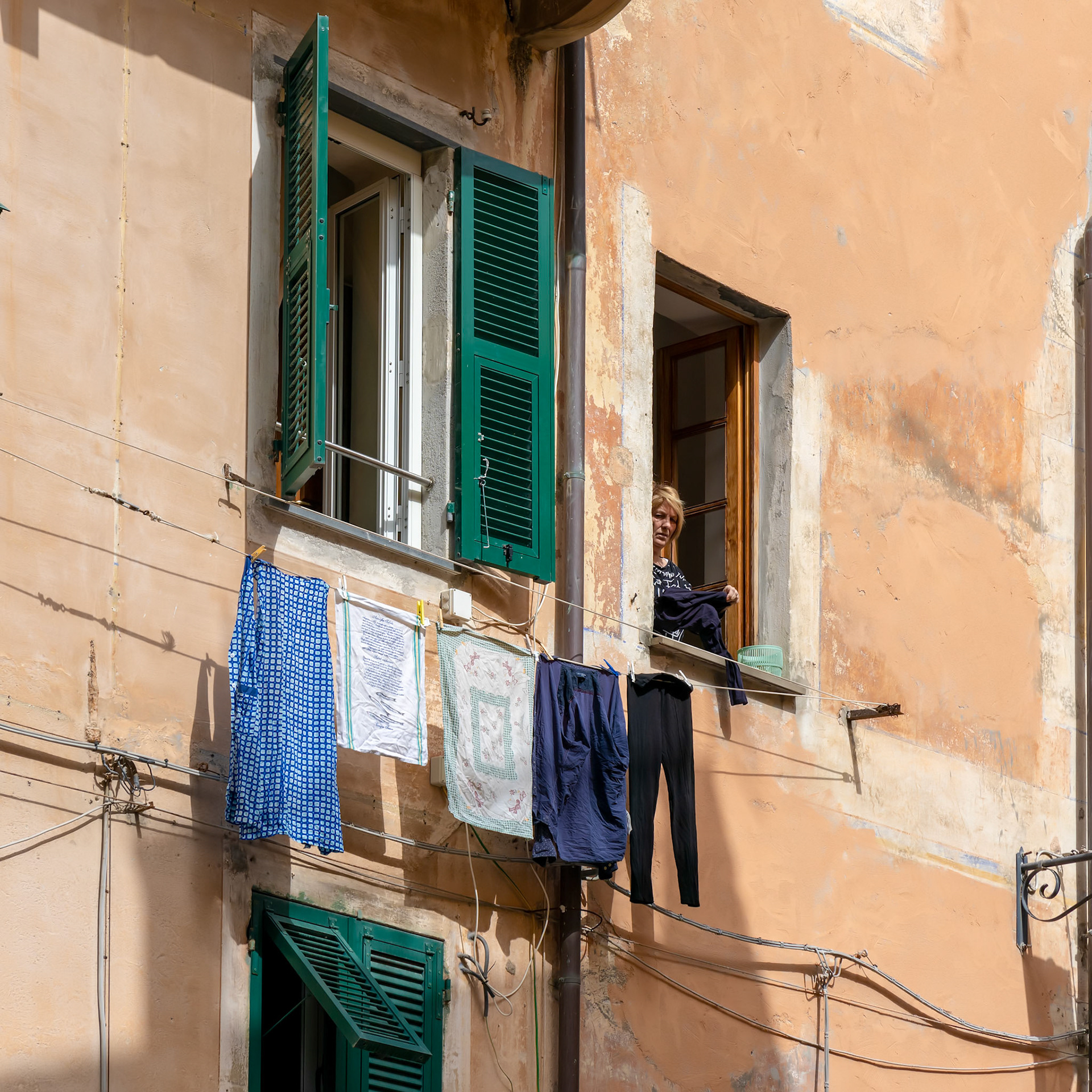 MONTEROSSO, LIGURIA/ITALY  - APRIL 22 : Woman hanging out the washing in Monterosso Liguria Italy on April 22, 2019. Unidentified person