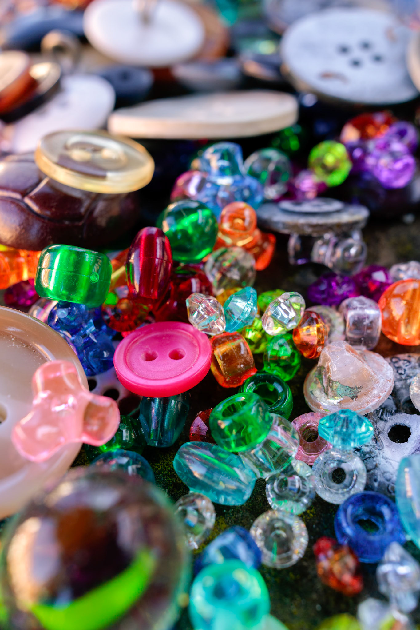 A group of randomly scattered beads, buttons and marbles