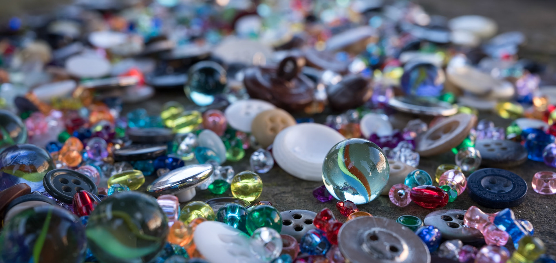 A group of randomly scattered beads, buttons and marbles