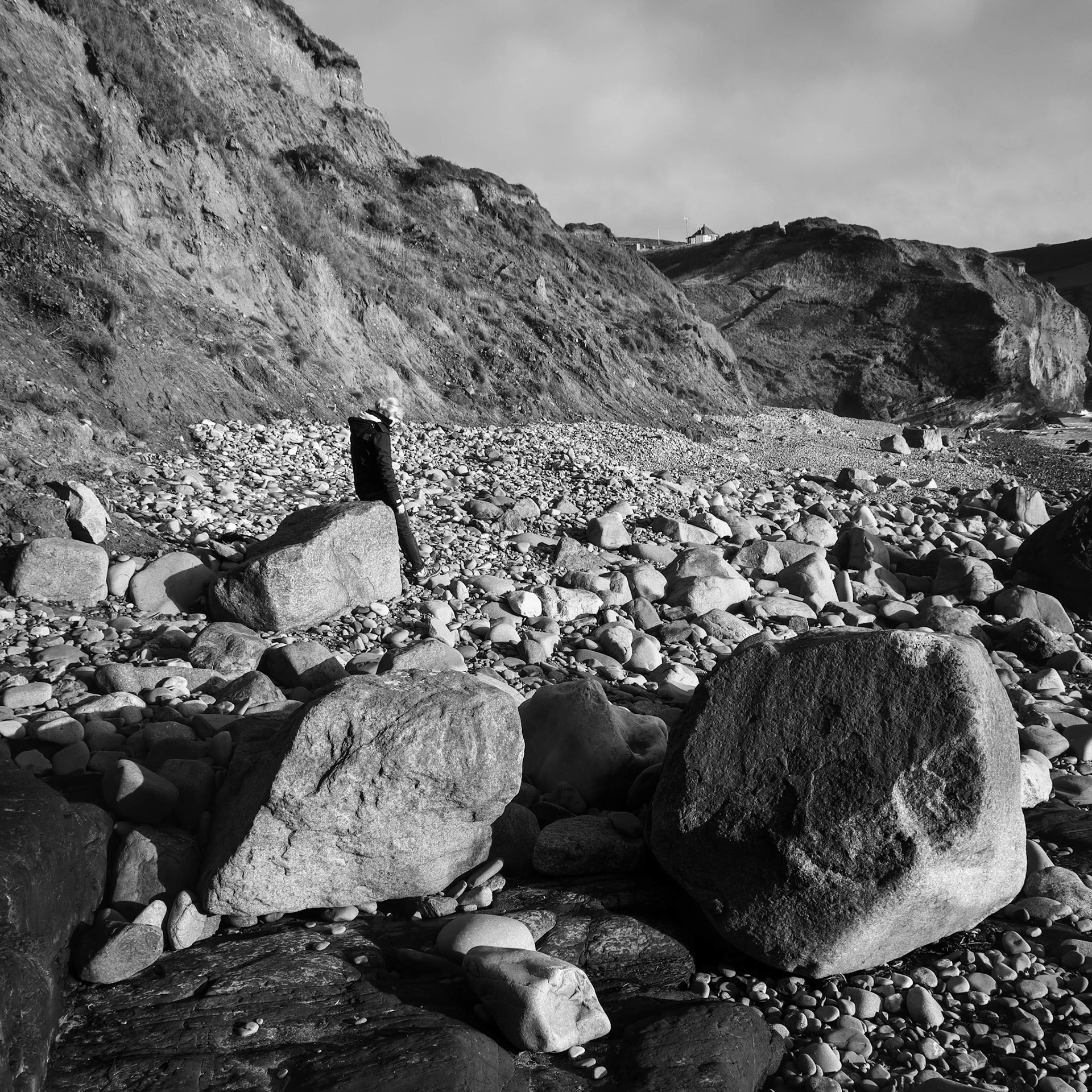 DRUIDSTON, PEMBROKESHIRE/UK - SEPTEMBER 11 : Woman sitting on a rock at Druidston Haven Pembrokeshire on September11, 2019. One unidentified woman