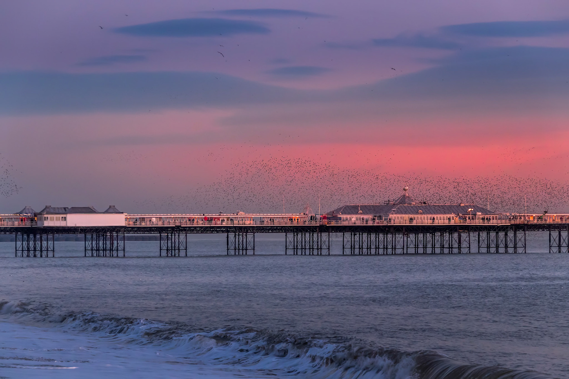 BRIGHTON, EAST SUSSEX/UK - JANUARY 26 : Starlings over the Pier in Brighton East Sussex on January 26, 2018. Unidentified people