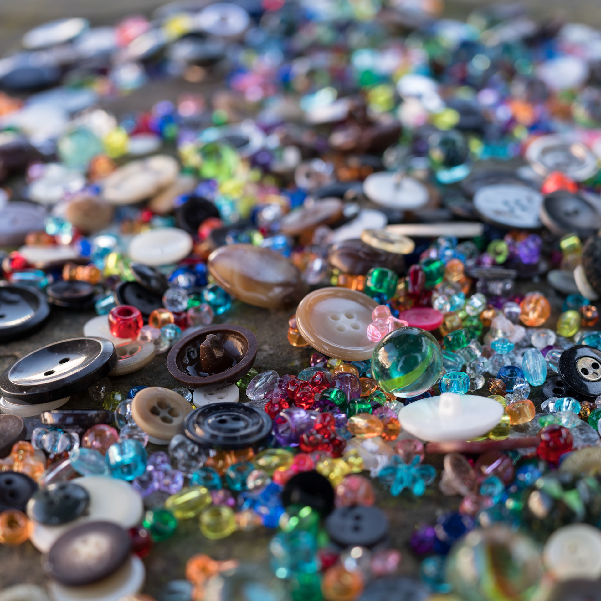 A group of randomly scattered beads, buttons and marbles