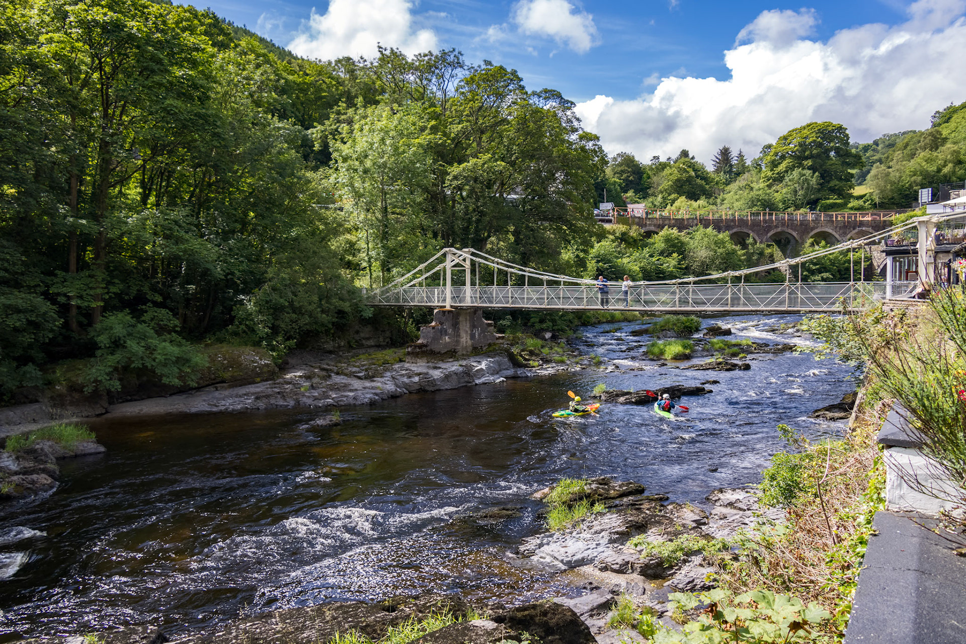 BERWYN, DENBIGHSHIRE, WALES - JULY 11 : People kayaking by the Chainbridge in Berwyn, Wales on July 11, 2021. Four unidentified people