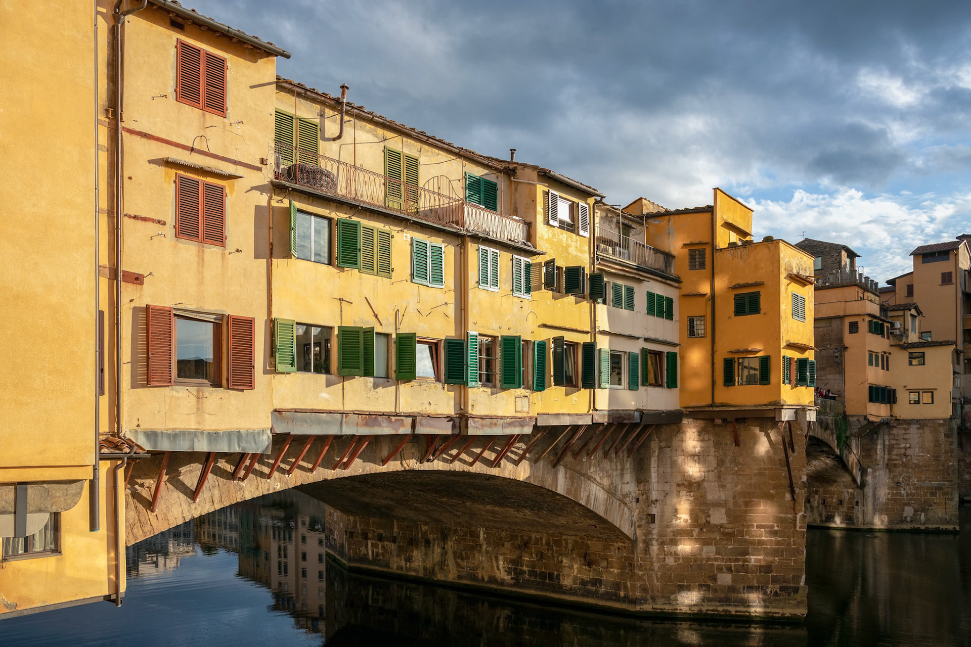FLORENCE, TUSCANY/ITALY - OCTOBER 18 : View of buildings along and across the River Arno in Florence  on October 18, 2019. Three unidentified people.