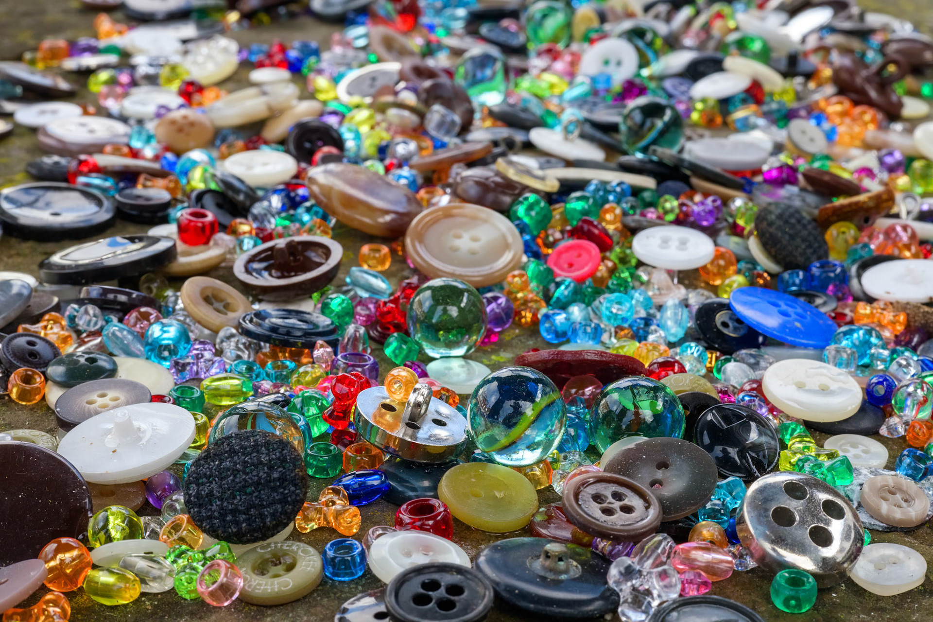 A group of randomly scattered beads, buttons and marbles