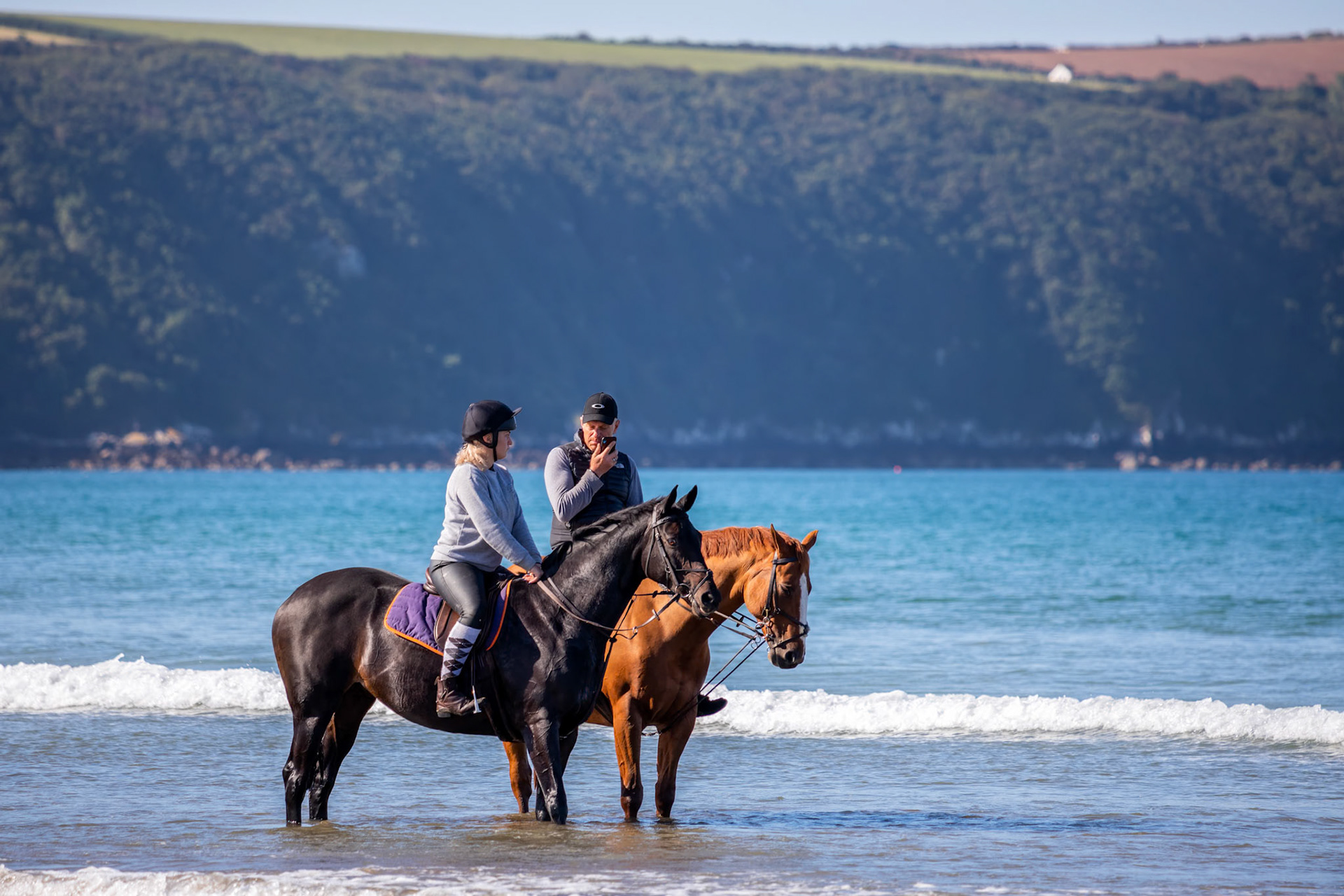 BROAD HAVEN, PEMBROKESHIRE/UK - SEPTEMBER 14 : People and horses enjoying the beach at Broad Haven Pembrokeshire on September14, 2019. Two unidentified people
