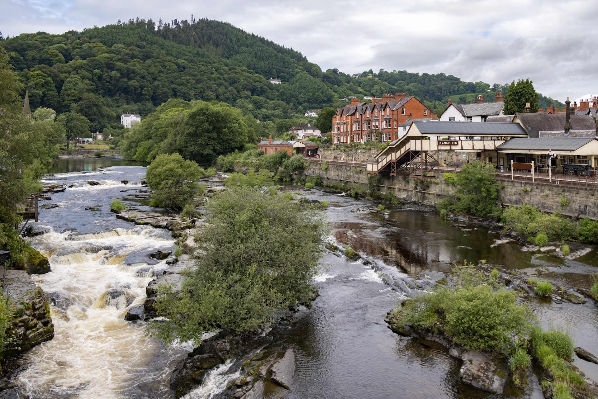 LLANGOLLEN, DENBIGHSHIRE, WALES - JULY 11 : View across the River Dee to the old station in LLangollen, Wales on July 11, 2021