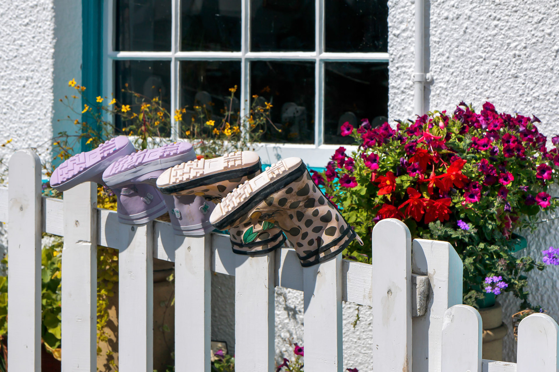 Two Pairs of Boots Placed on Fence Posts