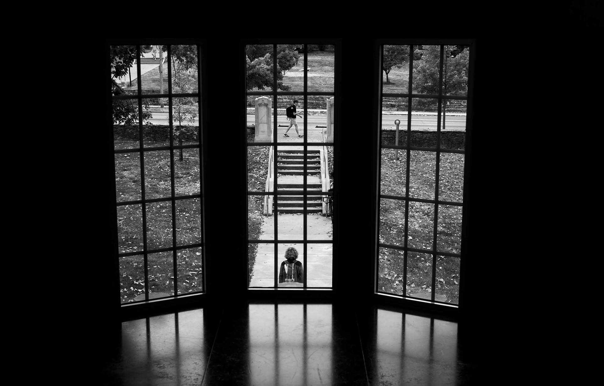Pedestrians framed in a campus window.