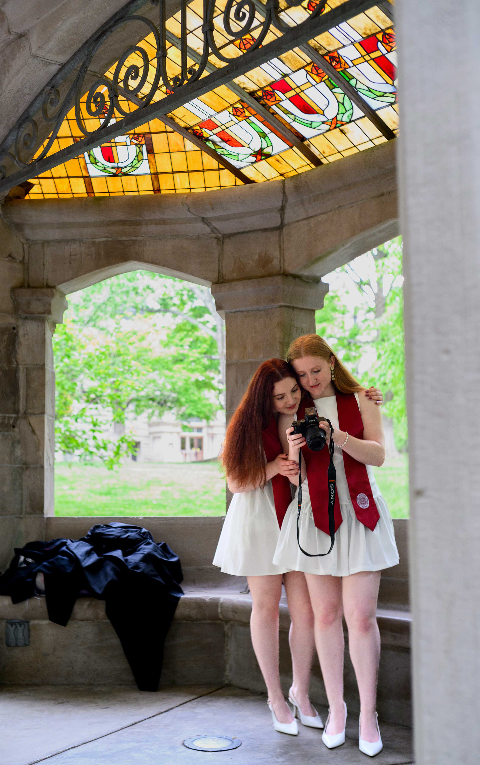 Twin sisters look over graduation photos.