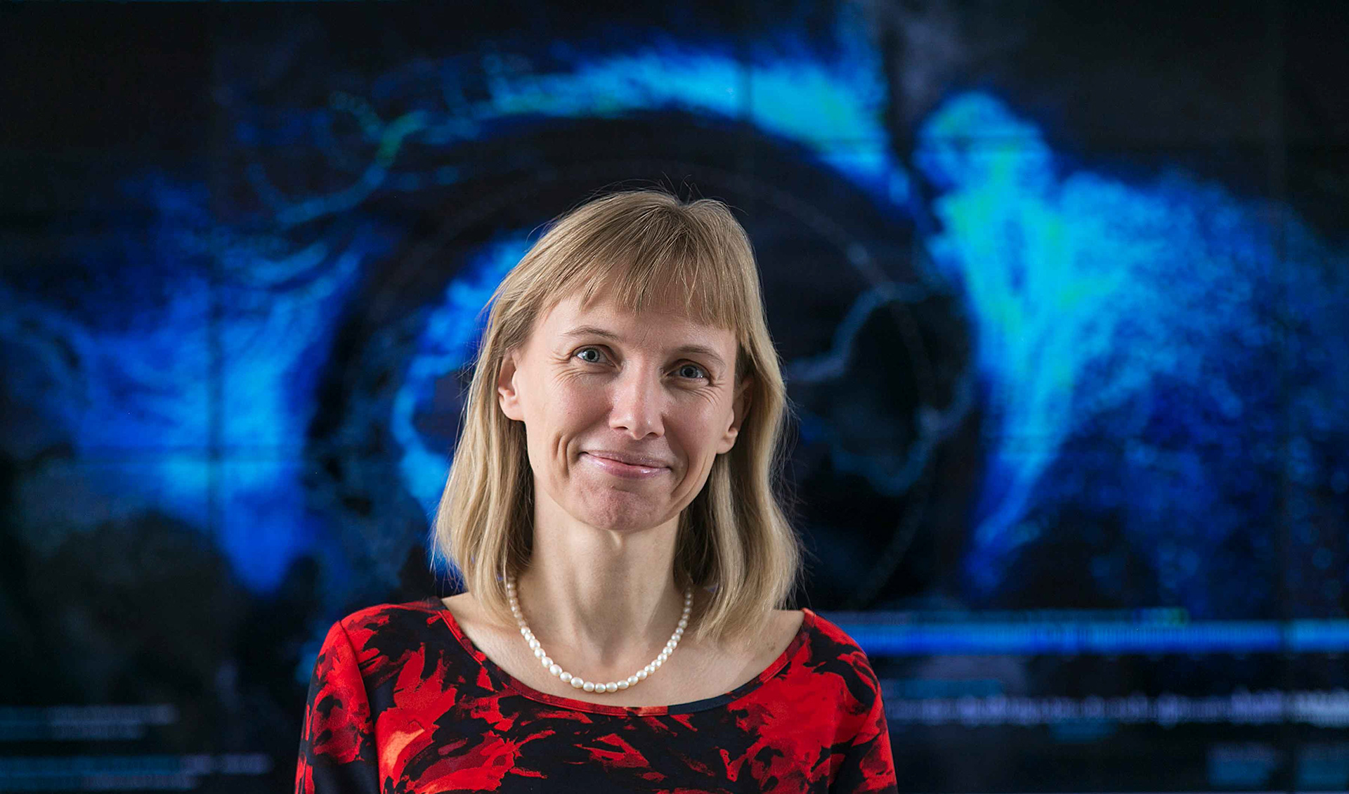Professor Katy Borner framed by a data visualization graphic.