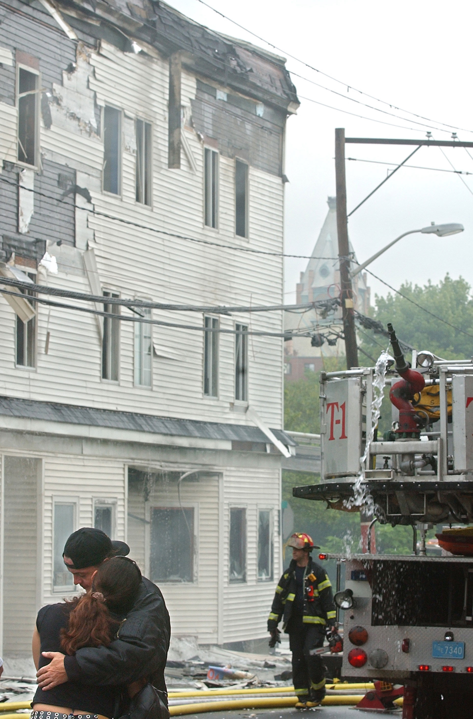 Dave Caradimos, originally of Halifax, gets a hug from his girlfriend after escaping an early morning fire in Brockton, MA.