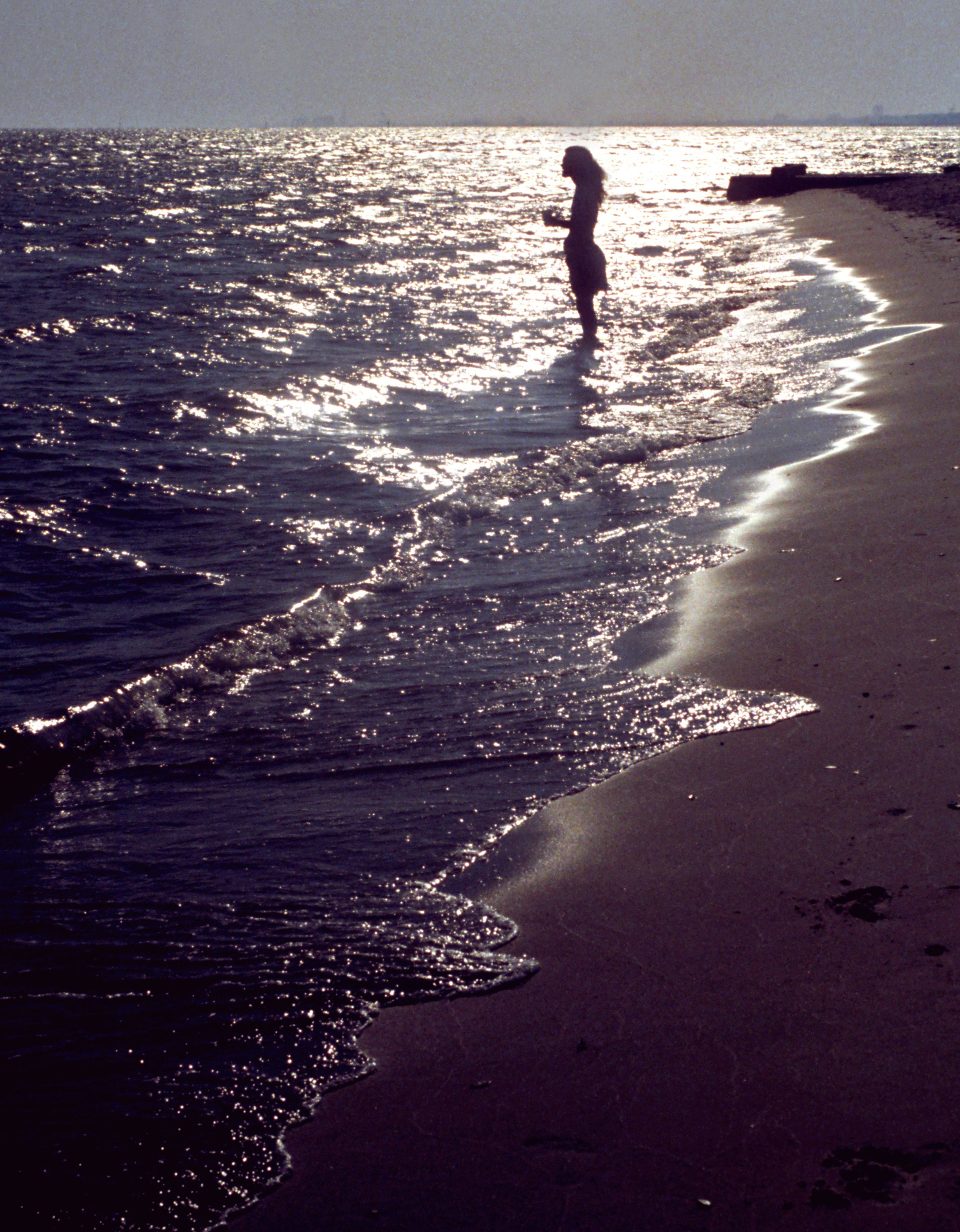 Mike Moore wades into the surf in Biloxi, MS.