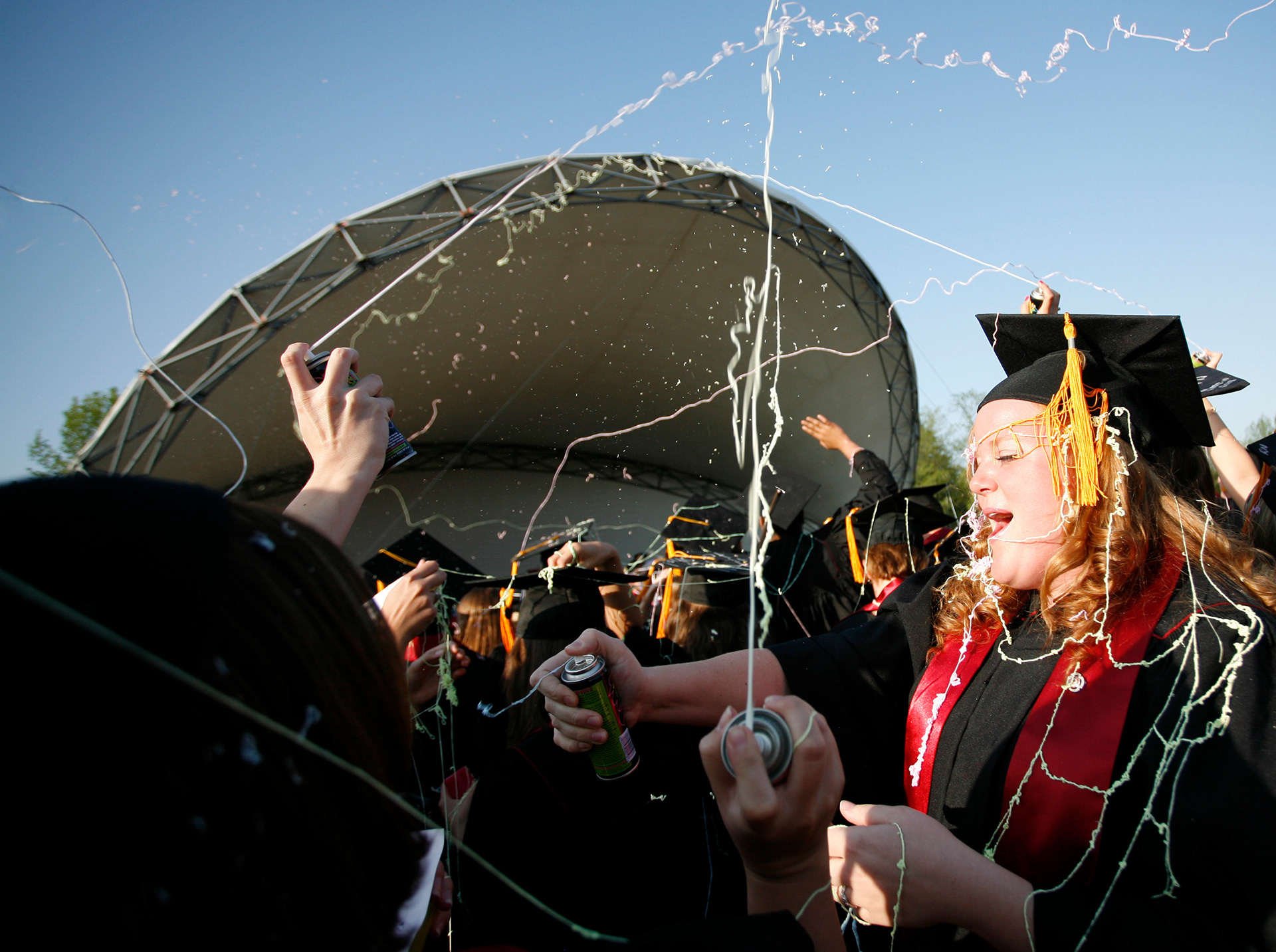 Melisse Ferree, right, participates in a Silly String fight with fellow degree candidates during commencement at IU Southeast.
