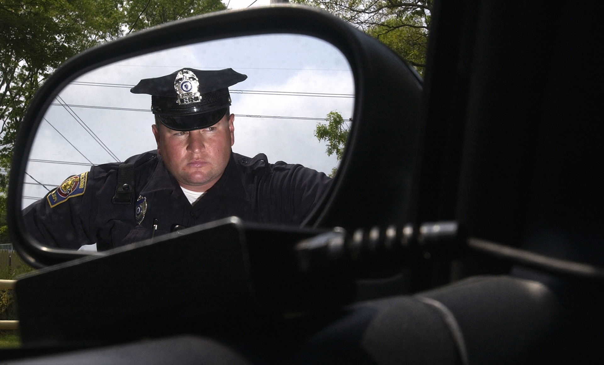Officer Daniel Matukas is reflected in the side mirror of his cruiser as he targets speeding motor vehicles.