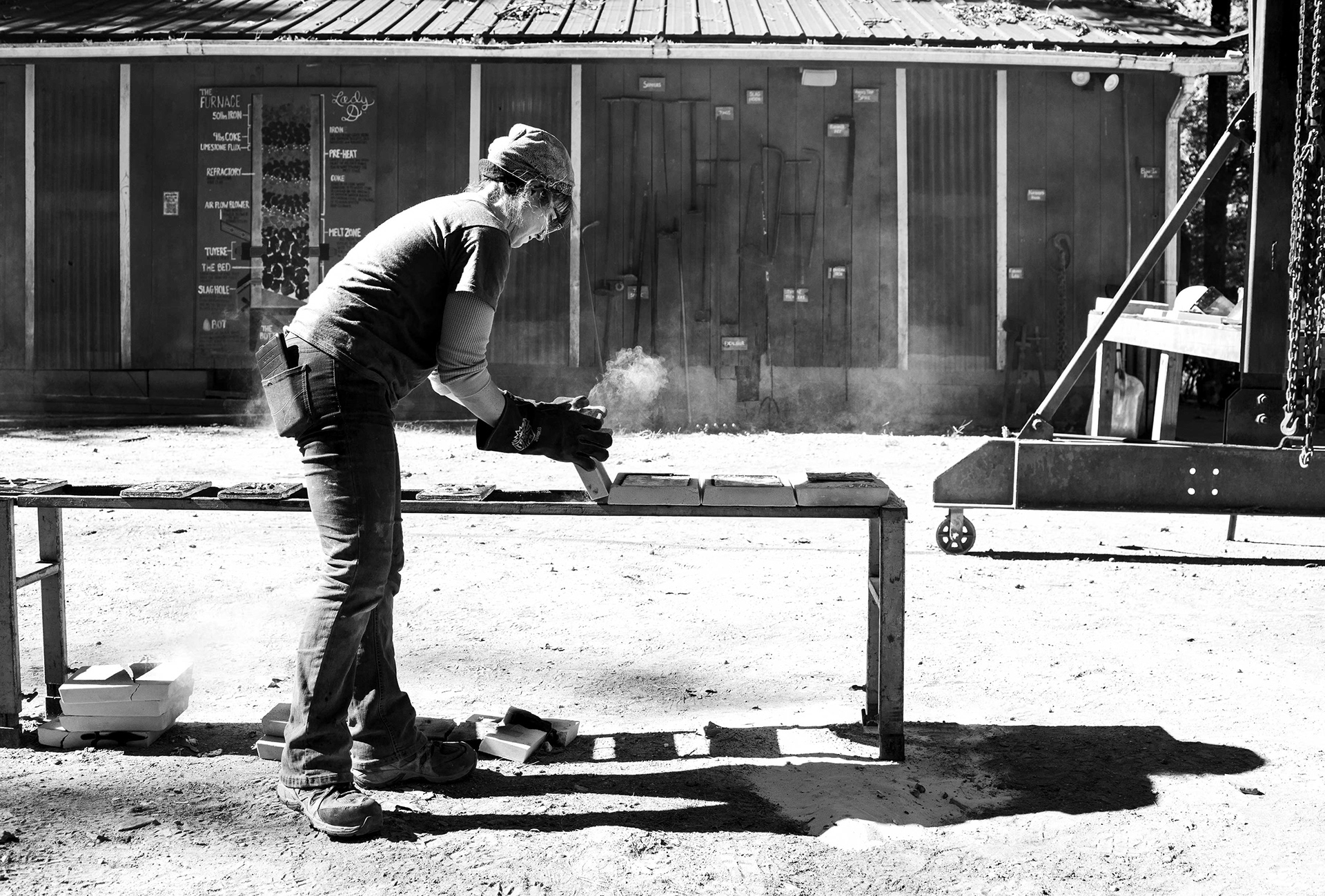 A metal worker removes aluminum casts for cooling.