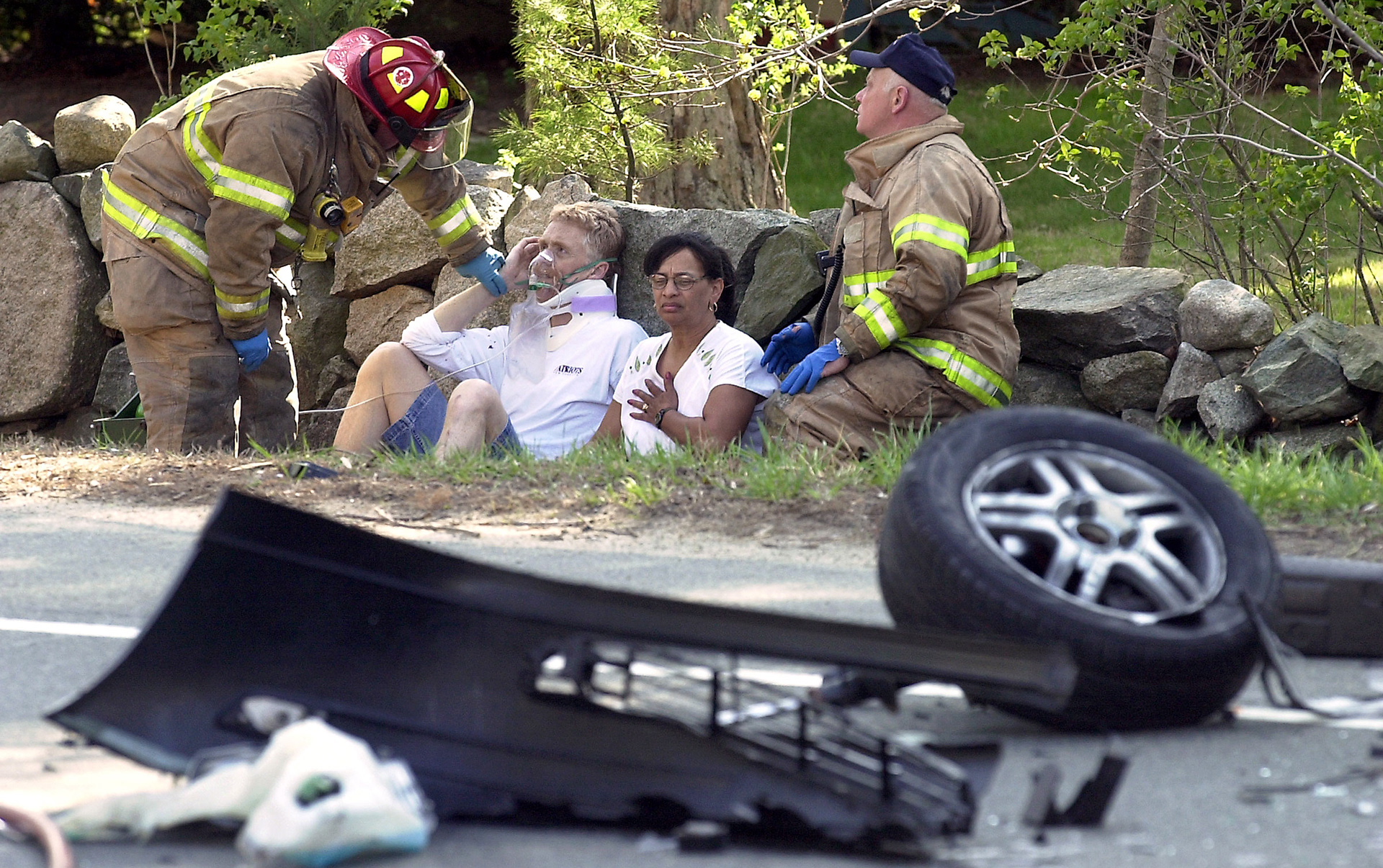 Firefighter Doug Hill, from left, tends to John Downey, 51, of Kingston, N.Y. as his wife Sydni is comforted by West Bridgewater Fire Captain Allen Breer following an accident on Route 138 in Easton, MA.