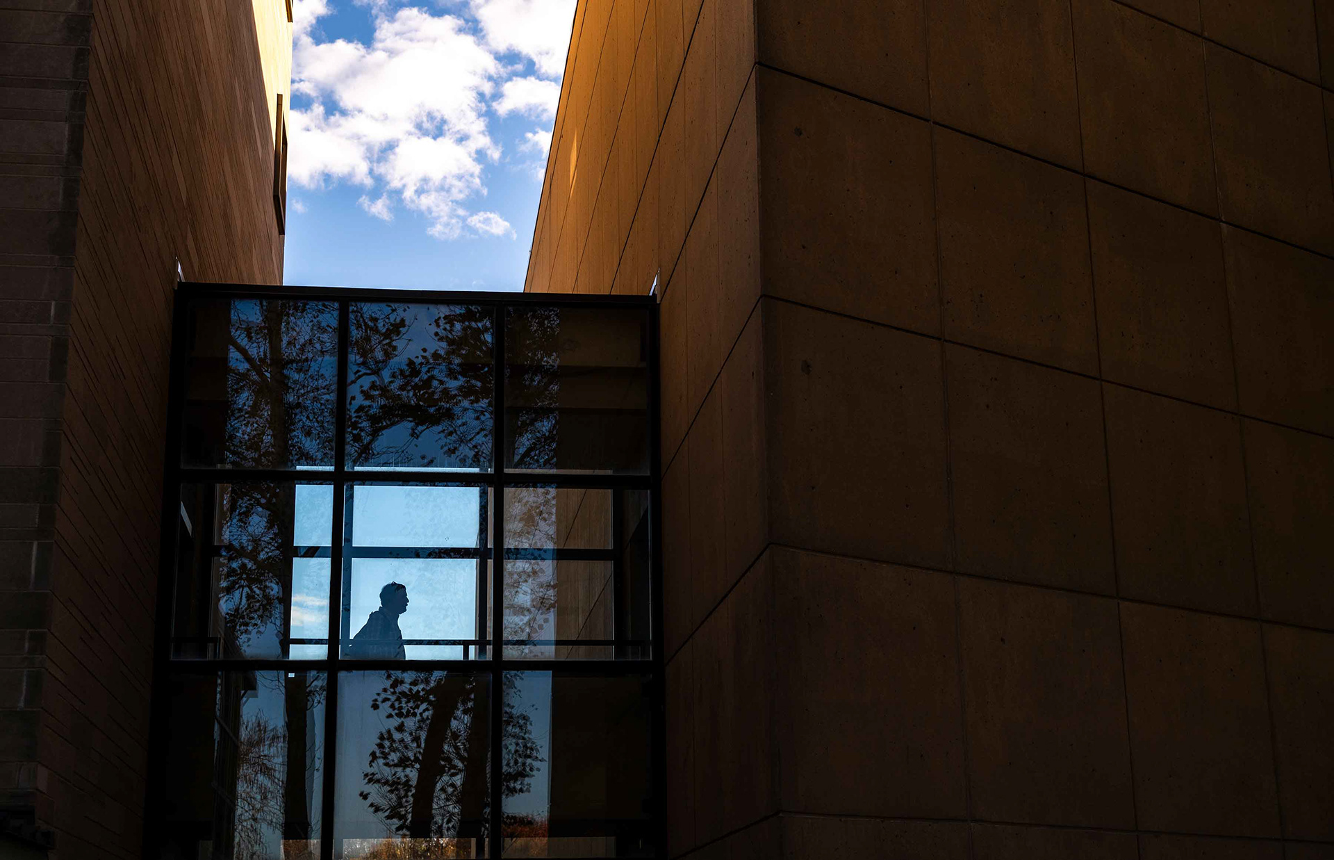 A pedestrian in a covered museum walkway.