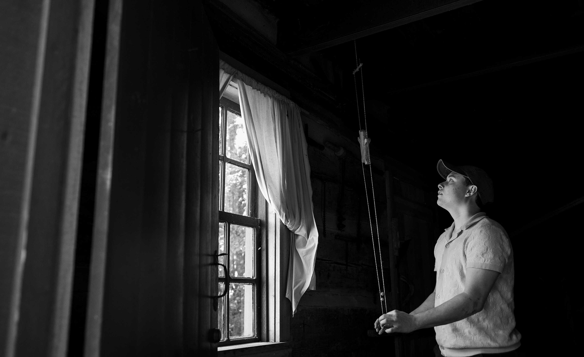 A rope climbing toy by cabin window light.