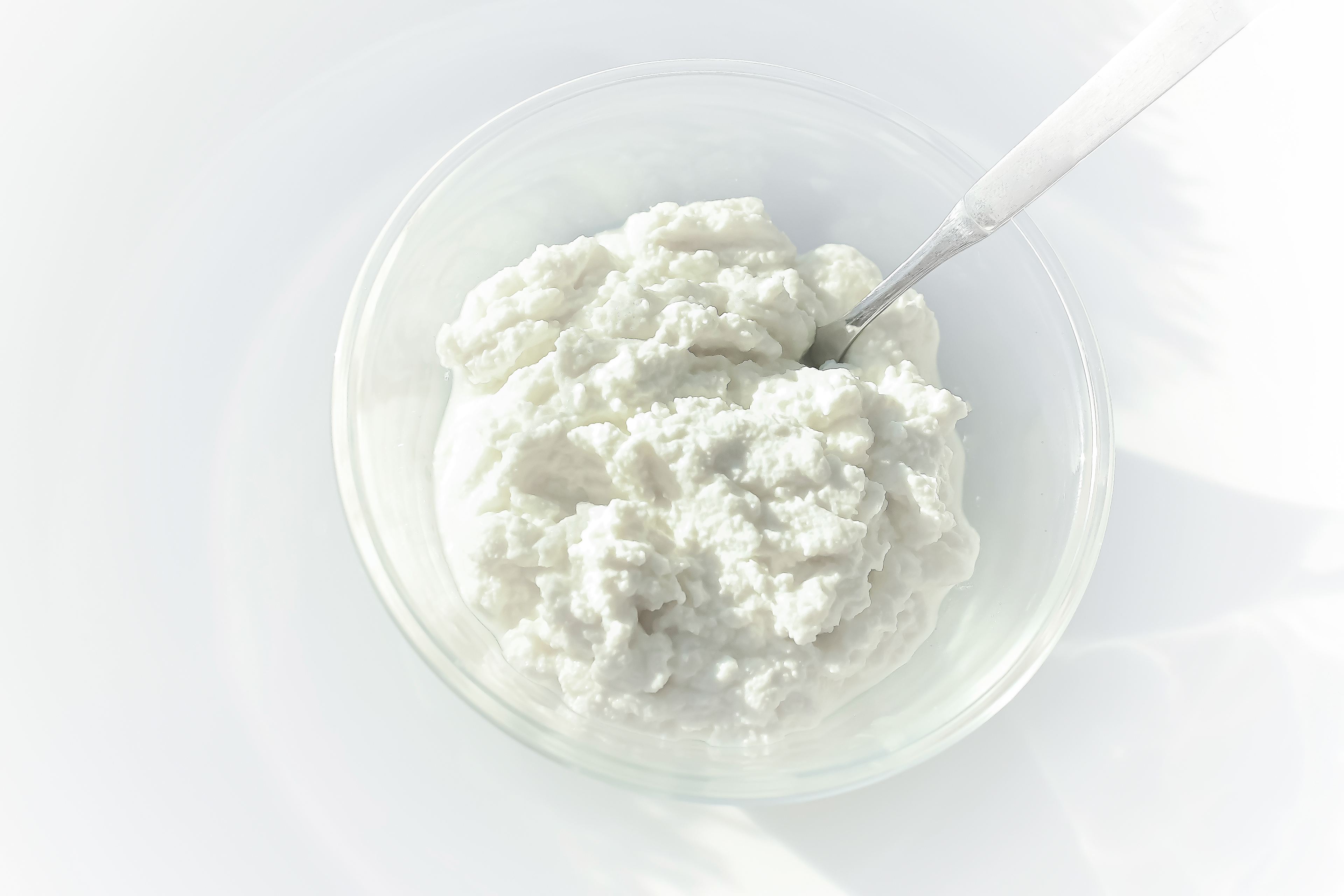 A white plate with roasted tomato bruschetta arranged on it, featuring slices of baguette topped with homemade ricotta cheese and roasted tomato quarters. The bruschetta is garnished with a sprinkle of freshly ground black pepper. The dish is set against a plain white background, highlighting the simplicity and freshness of the appetizer.