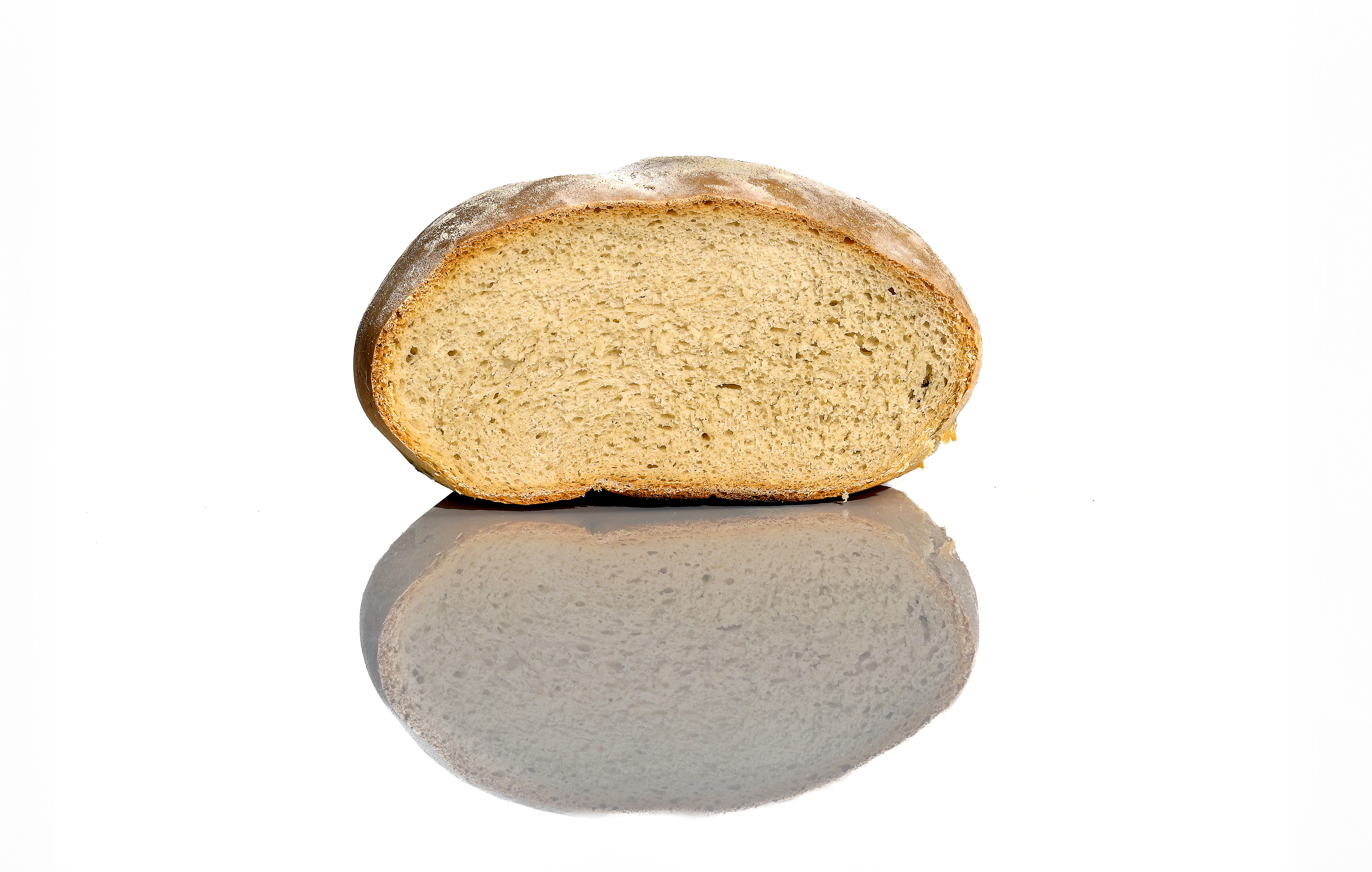 Homemade German Bauernbrot with a golden-brown crust and soft, airy interior, displayed on a clean white background