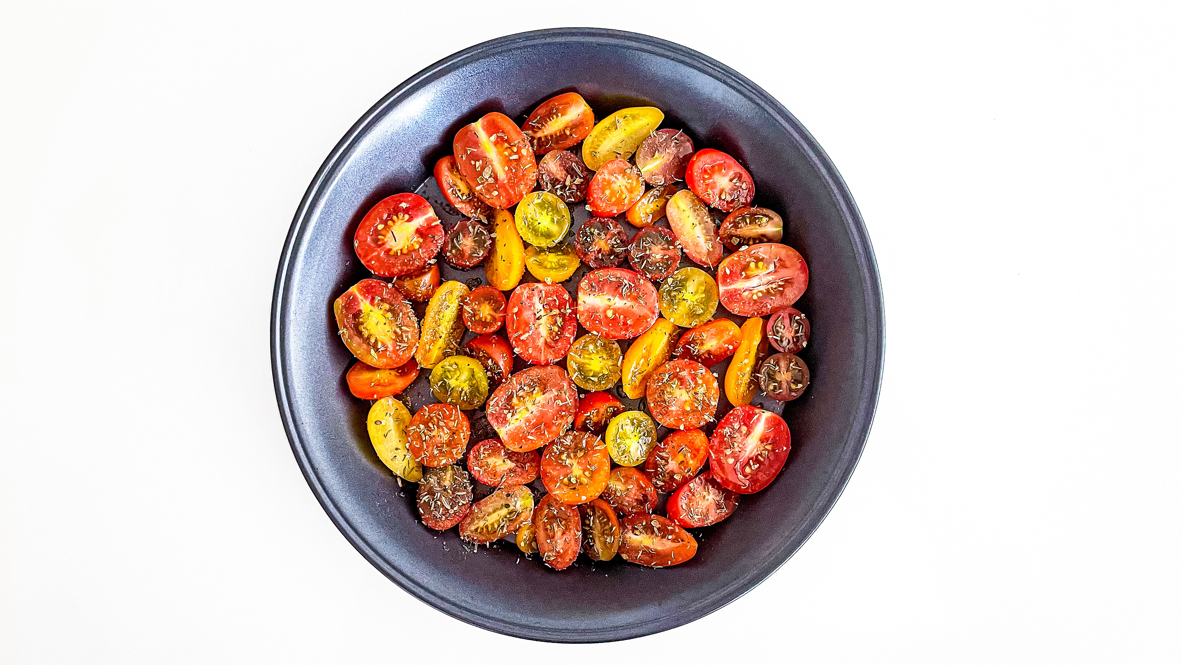 Oven Roasted Tomatoes in a round pan on white background.