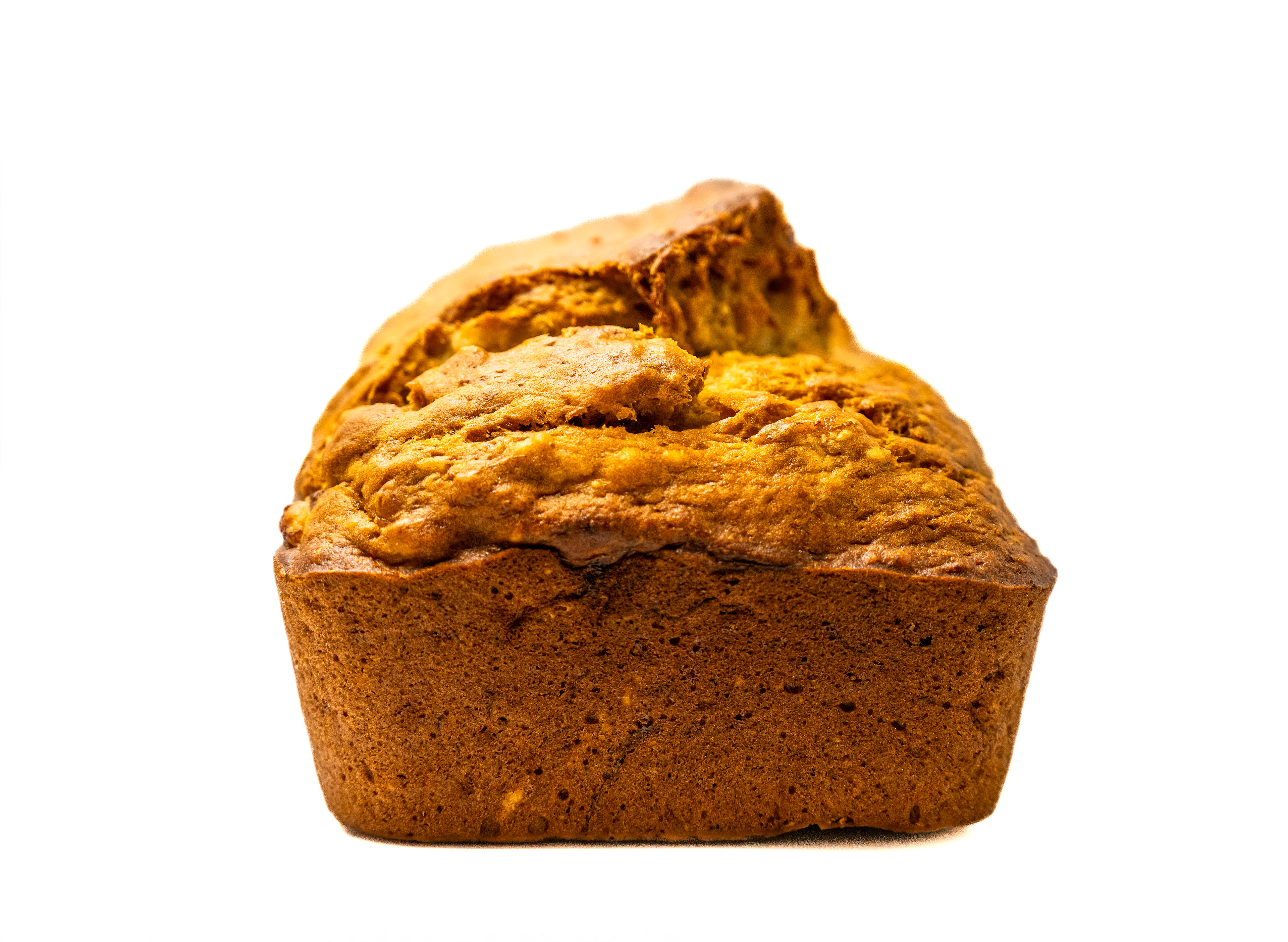 A whole loaf of moist banana bread with a golden-brown crust, placed on a clean white background. The texture appears soft and inviting, showcasing its perfectly baked surface.