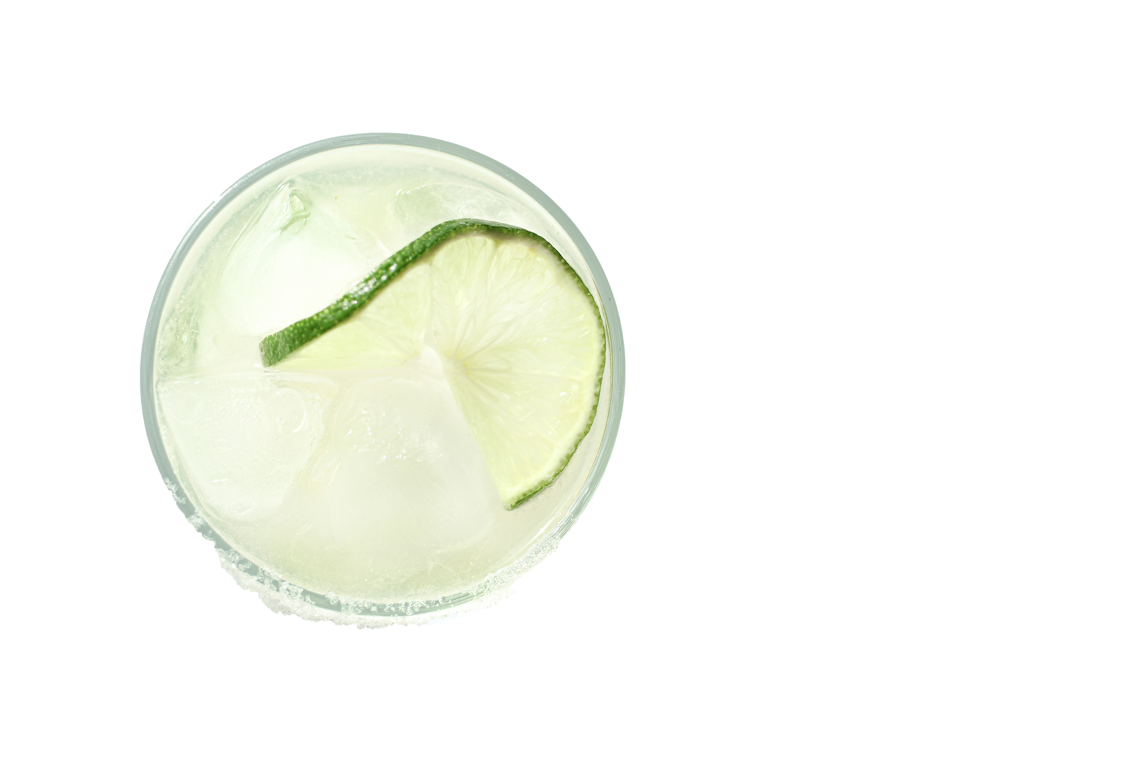 A classic margarita served on the rocks in a short glass with a salted rim. The drink is garnished with a fresh lime slice and filled with clear ice cubes, making the cocktail look refreshing and inviting. The image is taken against a white background, highlighting the simplicity and elegance of the margarita. The image was taken from above the cocktail.