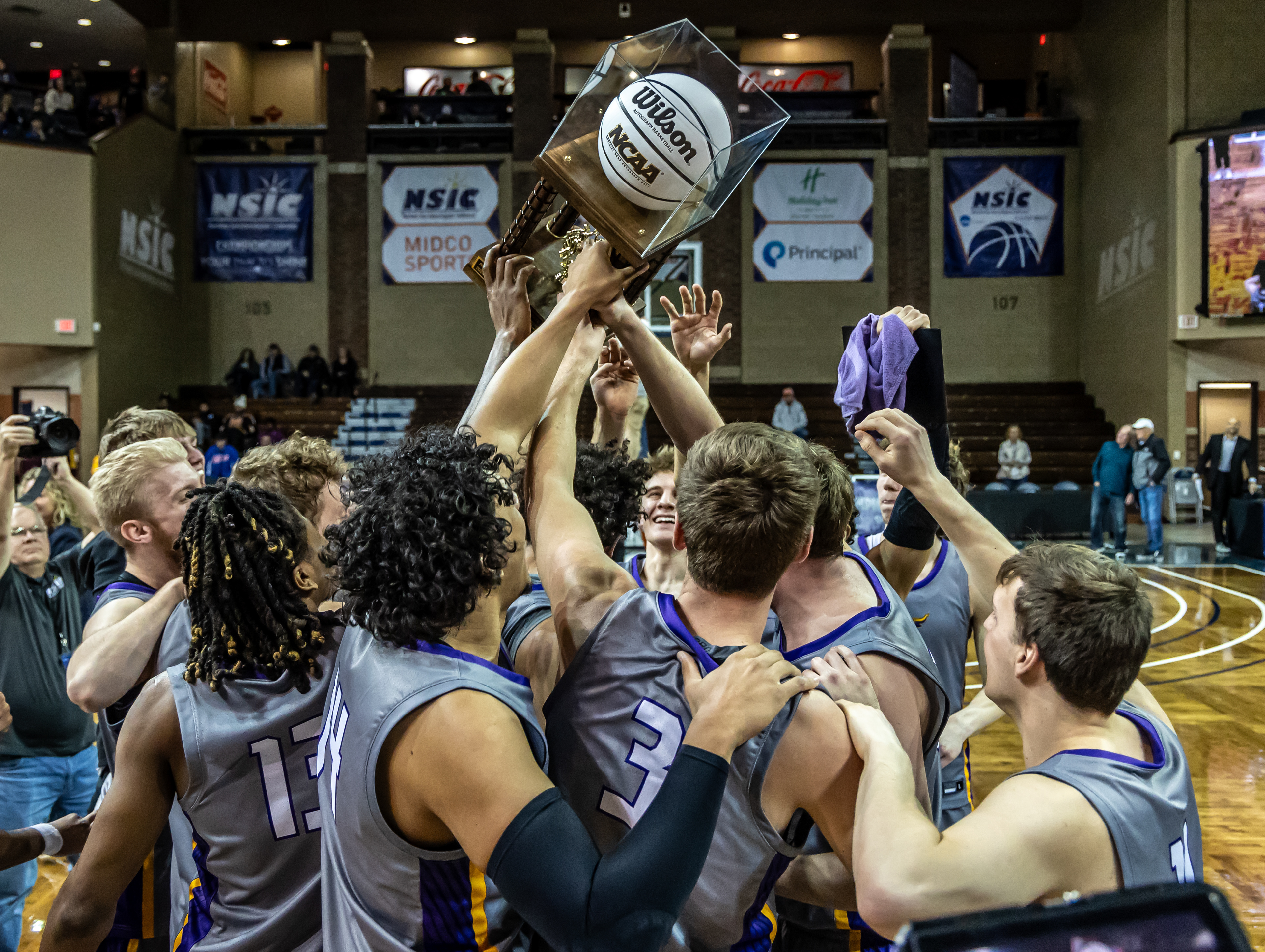 Minnesota State players lift the trophy after defeating Minnesota Duluth to win the NSIC Basketball Championship. The victory secured the Mavericks a berth in the NCAA National Tournament and capped off a dominant postseason run.