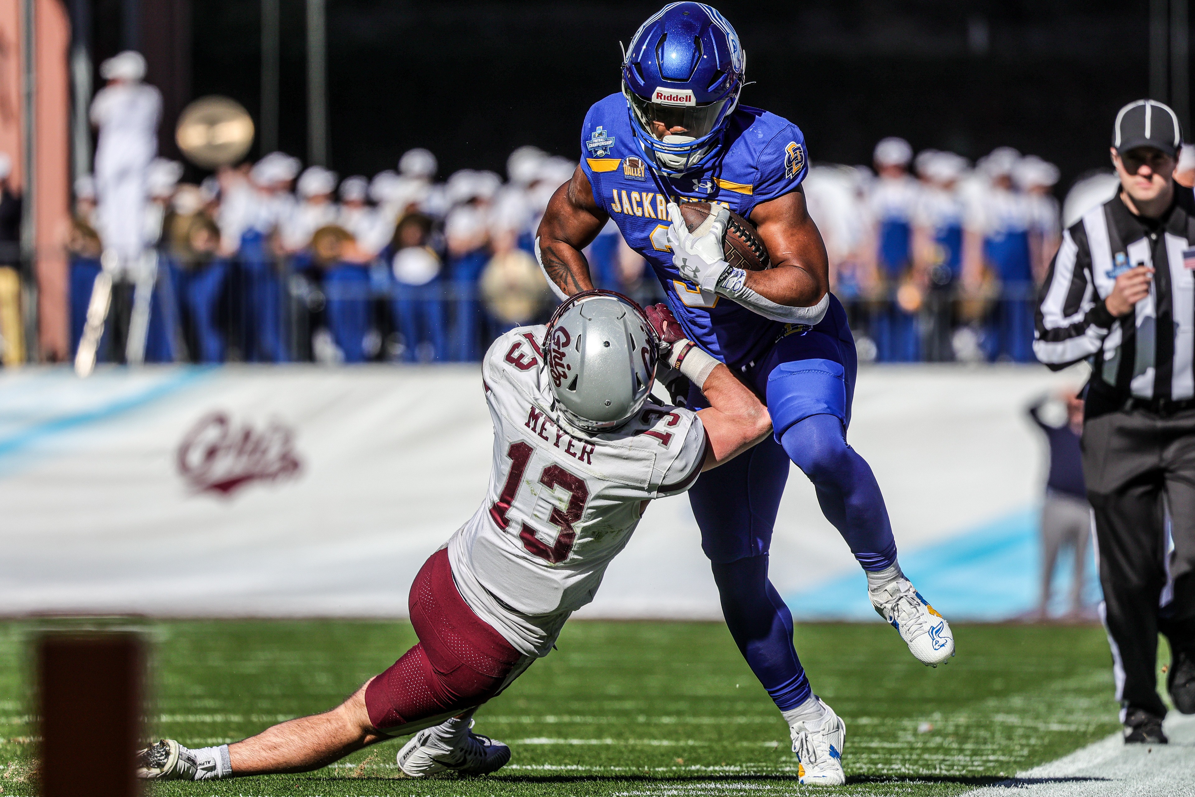 Running back Amar Johnson lowers his shoulder through a Montana defender during the 2023 FCS National Championship in Frisco, Texas. His hard-fought conversion on a crucial third down helped extend a key Jackrabbit drive.