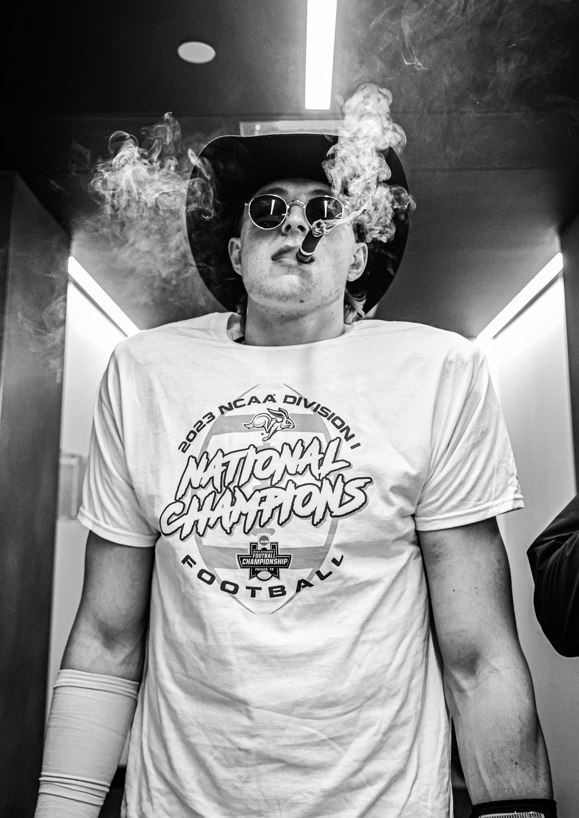 South Dakota State quarterback Chase Mason celebrates in the locker room after the Jackrabbits’ 2023 FCS National Championship victory. With a cigar, cowboy hat on, and championship shirt draped across his shoulders, Mason embodied the swagger of a team that had just completed a perfect season.
