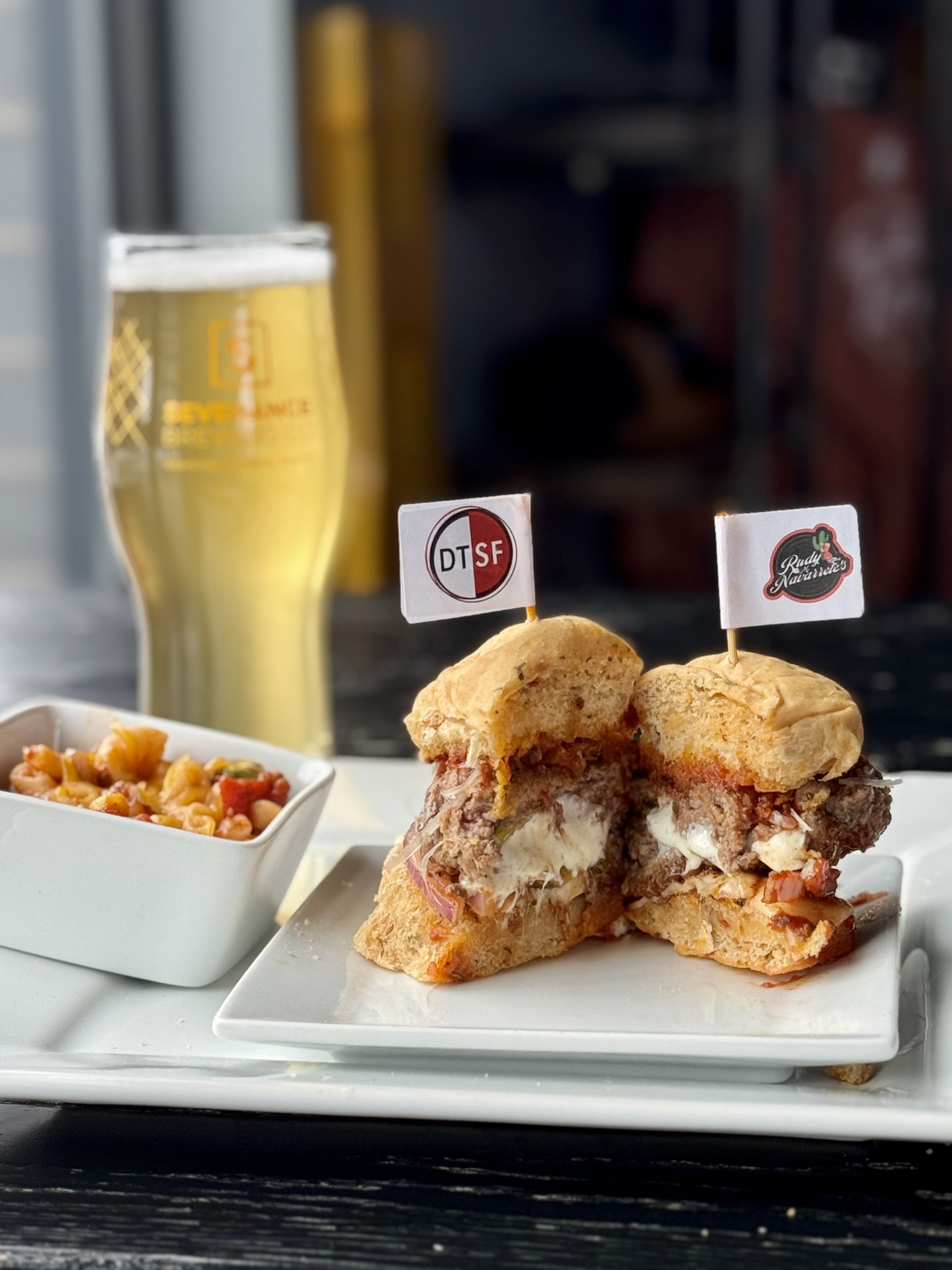 Mama Mia! - Severance Brew Co feat. Rudy Nav. Tex Mex - A garlic-toasted tomato basil bun from Breadsmith is stacked with provolone, red onion and an Italian-seasoned all beef slider that’s stuffed with fresh mozzarella and pepperoncini and then smothered with a homemade marinara. Topped with freshly grated Parmesan and crushed croutons. Garnished with fresh jalapeño and a side of Italian goulash! 