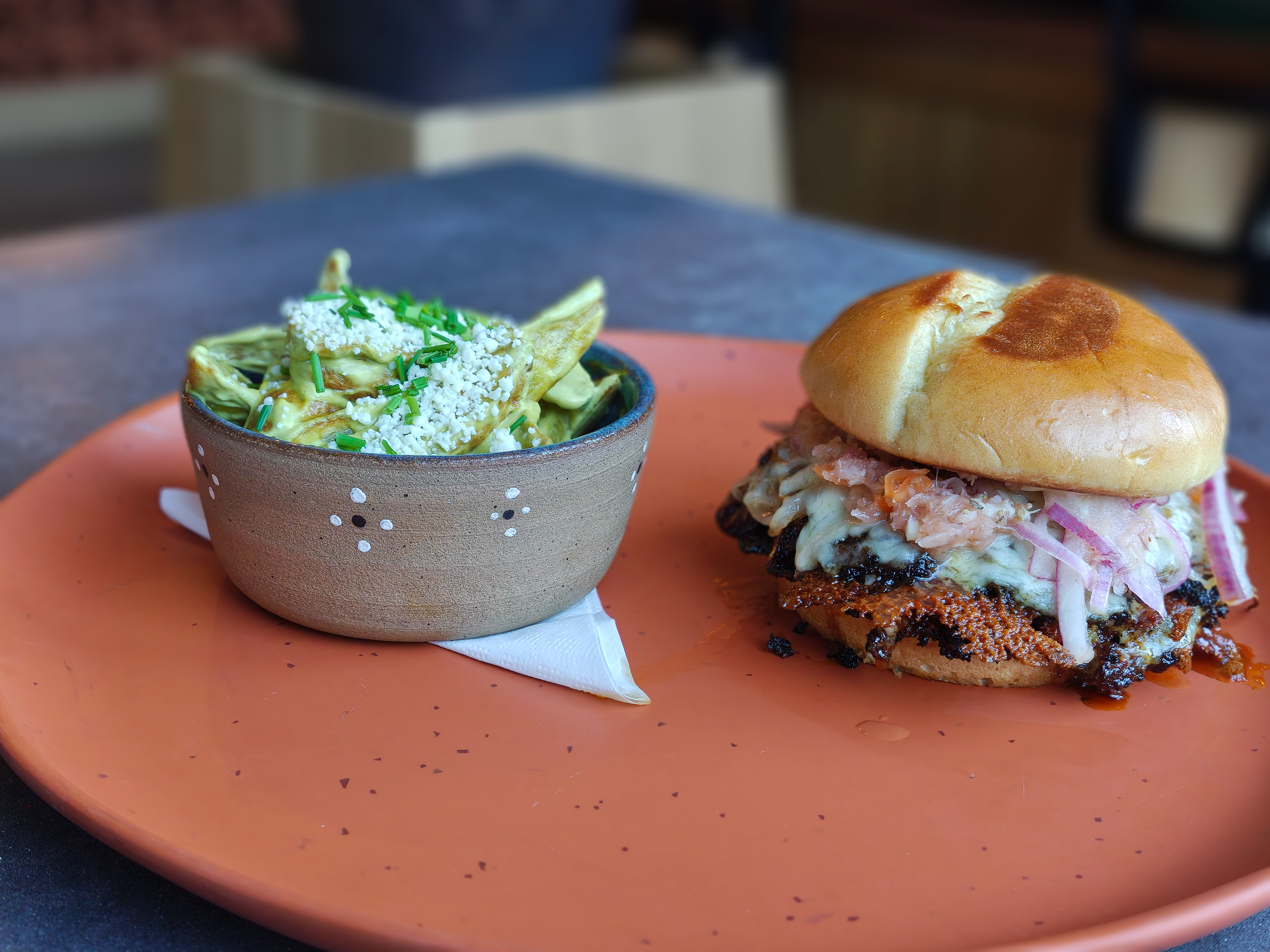 Smash Pastor - Bibisol - Two local Svec grass fed grass finished all SD beef patties marinated in annatto seed topped with monterrey jack cheese, pineapple garlic aioli, Pineapple Xnipec Salsa on a local bolillo bun from Manna Bakery! Served with a side of creamy Poblano wedges topped with cotija cheese and local chive.