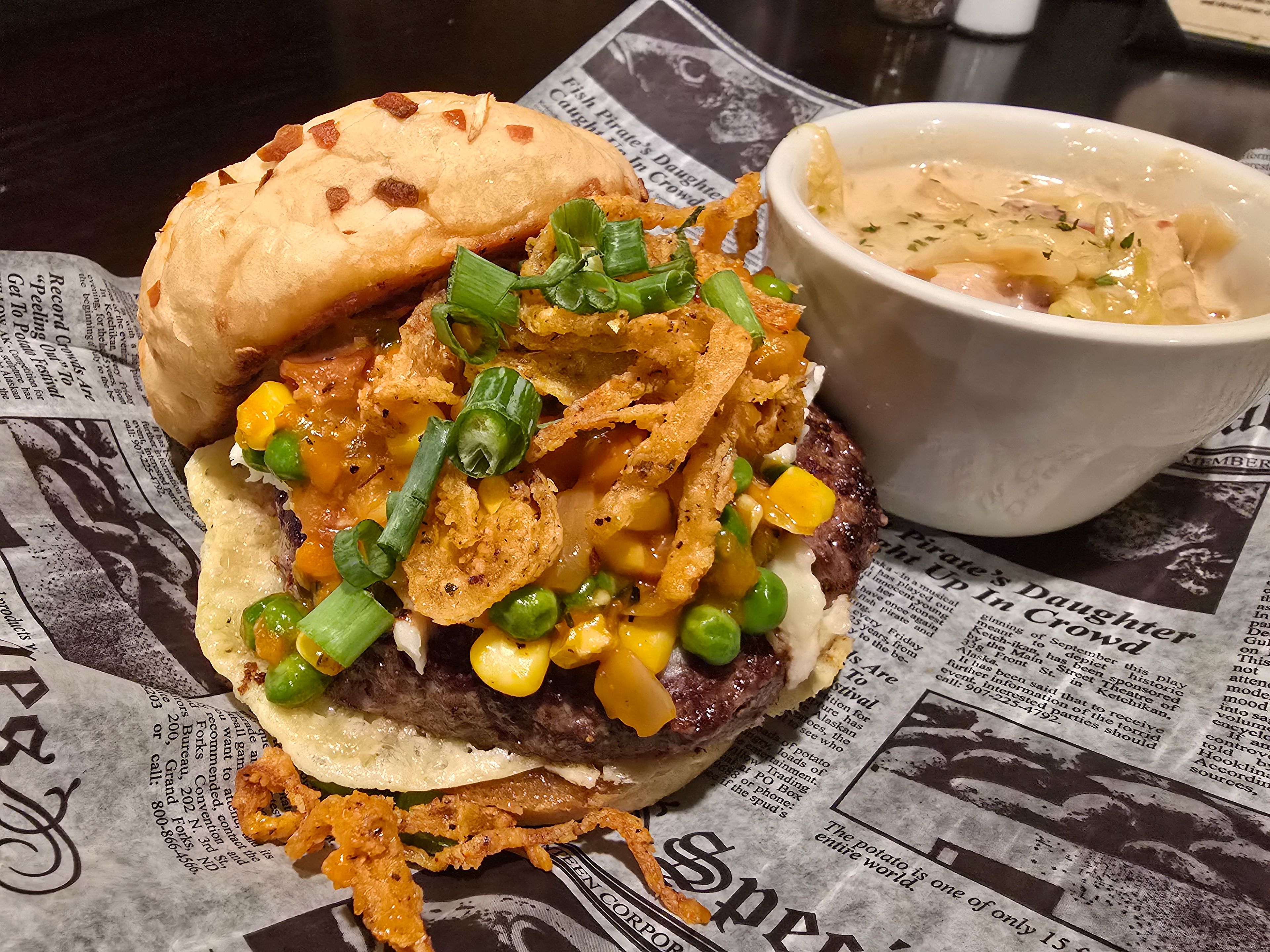 The Shepherd's Pie Burger - Blarney Stone - A 1/8” fine ground 7 oz. Fire River Farms Burger Patty placed on a freshly oven-baked Swiss Cheese crisp on top of a Garlic Butter toasted, Caramelized-Onion Bun. Topped with Champ Potatoes, and a medley of Carrots, Peas, Corn, Onions, Garlic & Bacon. Finished with Fried Onion Strings and fresh chopped Green Onions. 