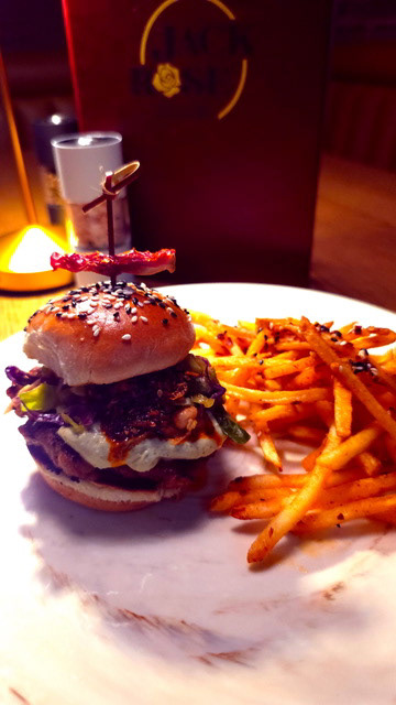 Jack Thai Pork Slider Burger - Jack Rose Social Club - Brioche Sesame Seed Bun, pork belly and ground pork patty, jalapeño cream cheese, Thai peanut vinaigrette, Thai slaw, crispy chile crunch, Pickled ginger. Spiked with a Thai chili for the daring to take spice level to 11!  Served with ramen spiced shoe string frites.