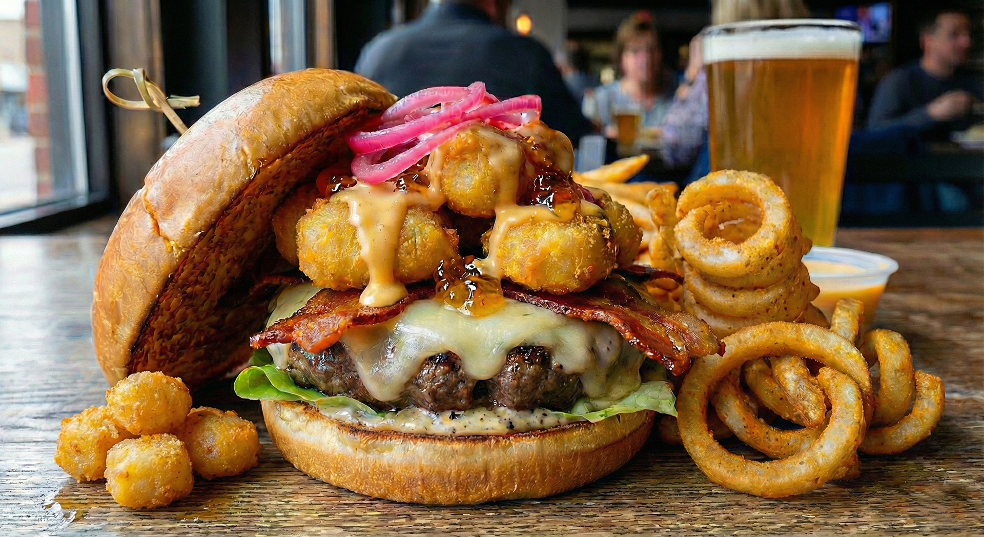 Cheese Curd Crunch Burger - Boki European Street Food - Crispy hand-battered cheese curds take center stage on an 8 oz Angus beef patty layered with a touch of butter lettuce, sharp white cheddar, and apple wood-smoked bacon. Finished with bright pickled red onions, a touch of pepper jelly, garlic black-pepper aioli, and an optional light beer cheese drizzle, all served on a toasted Hawaiian bun. Served with a generous side of fresh-cut curly fries. Sweet, savory, and packed with flavor.