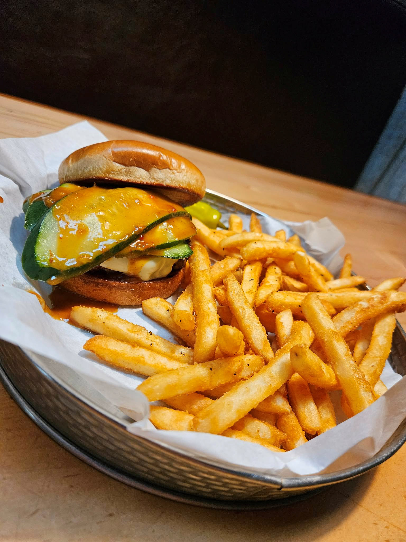 The Bangkok Burger - MacKenzie River - A flame grilled beef patty with a melted pepper jack cheese topped with some bold and spicy cucumbers with a drizzle of a zesty Thai chili sauce.
