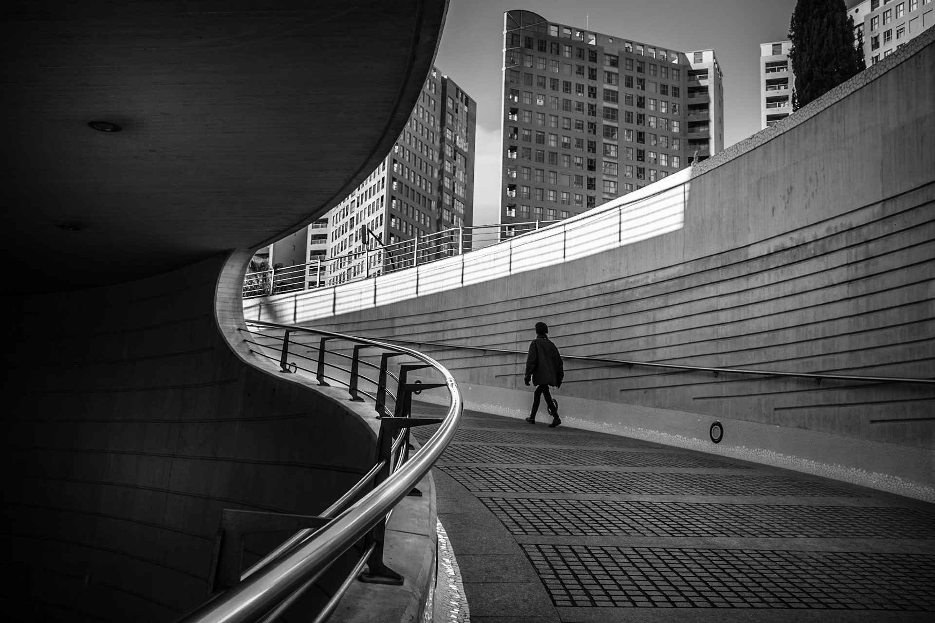 Valencia, City of Arts and Science. A nice place to take shots of vanguard architecture. This photography was made in the morning, the light was lateral and strong. I love to include people on the scene, adds more life to the cold concrete. Find original and strong compositions here is not an ease task. There are too many possibilities, many of them already repeatedly photographed. Here I used curves and lines including a silhouette of a woman who didn't noticed she was a very important component in my shot.