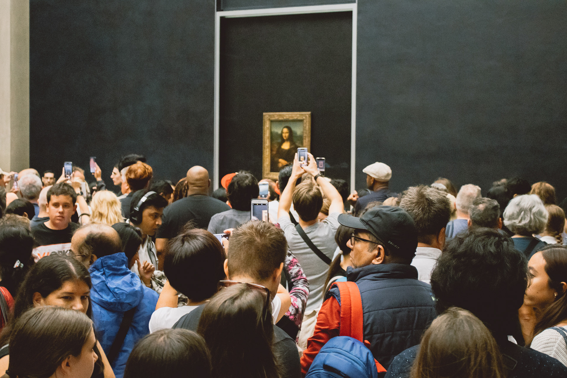 A crowd of people waiting in line to take pictures of the Mona Lisa