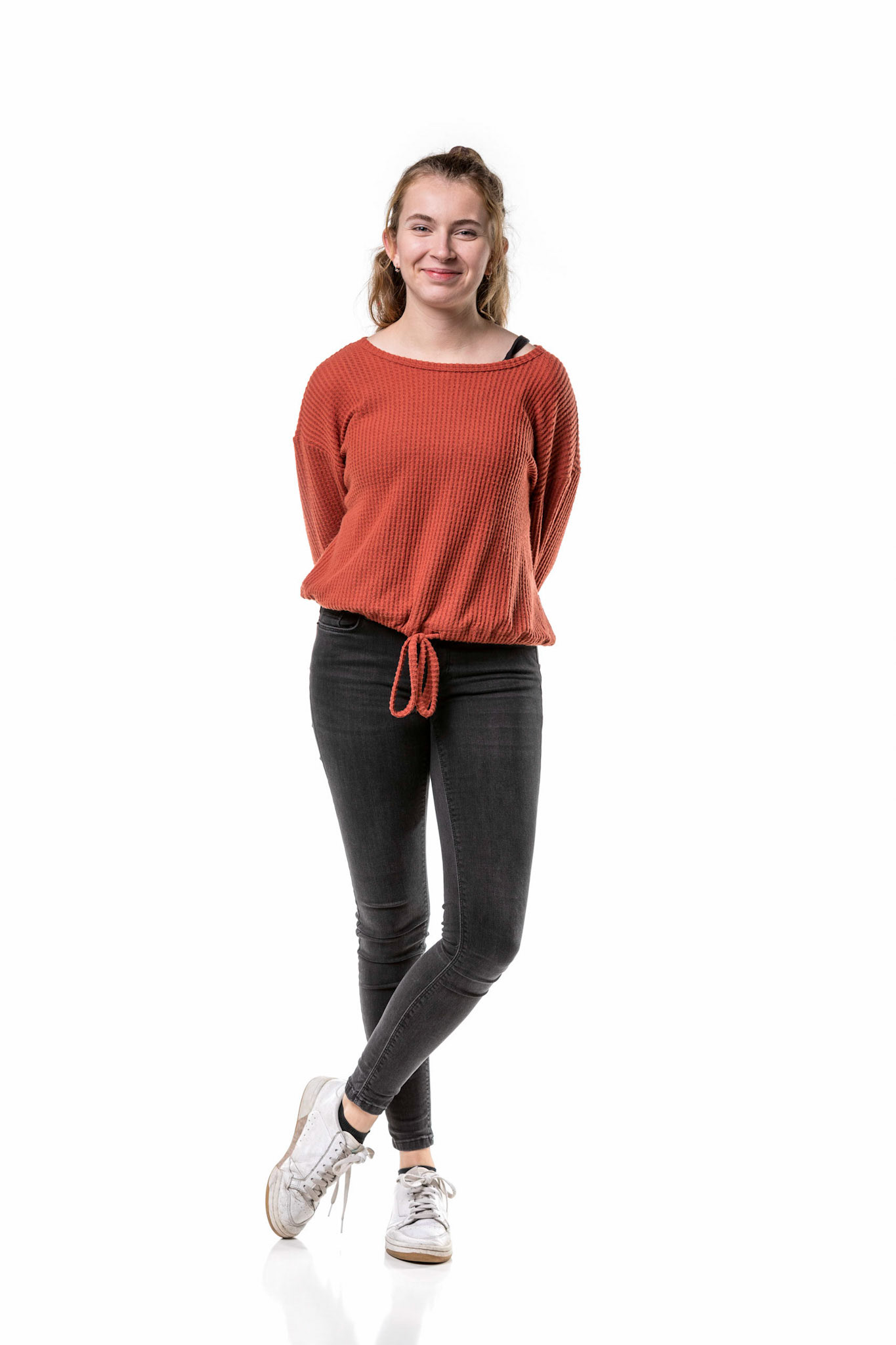 A beautiful caucasian generation z girl standing in casual clothes with her feet crossed isolated on a white background