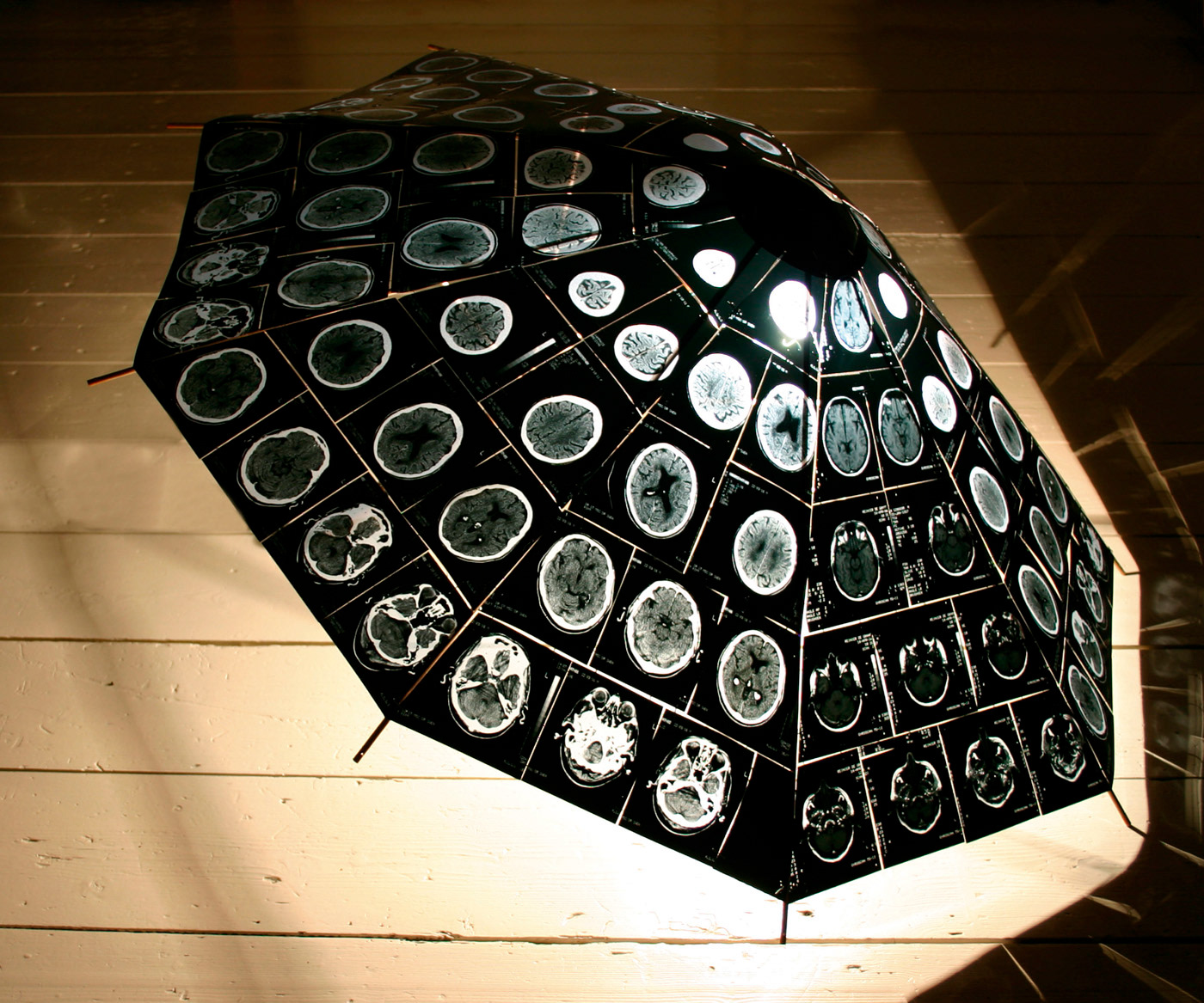 Umbrella, wood and x-rays, 9 people with brain damage, 12 x-rays of each brain, brought together in one object, 120 x 120 cm.