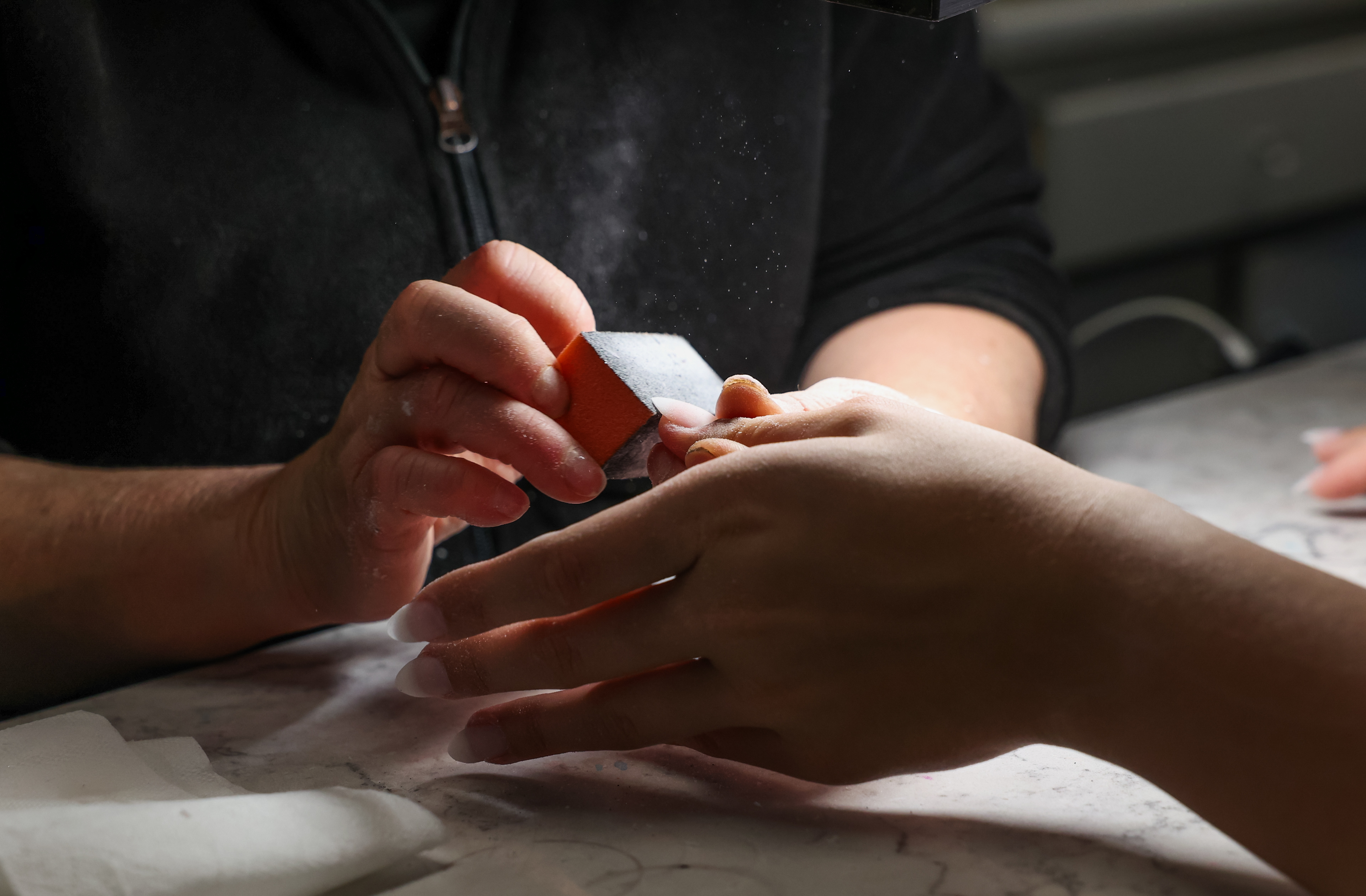Stylist Kimberly Truong, left, does Ellie Thompson’s nails on Saturday, April 20, 2024, at Elegant Nails in Owensville, Mo. Thompson’s almond cut, black, red and sparkly nails matched her prom dress and her date’s suit.