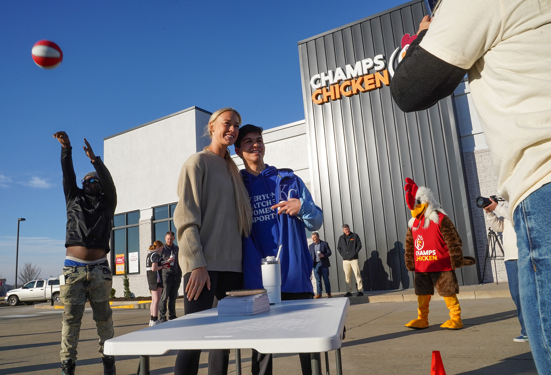 Indiana Fever guard Sophie Cunningham poses for a photo with Jack Yamada while Denzel Pickens shoots a free throw Saturday morning on Saturday, March 8, 2025, at Champs Chicken in Columbia, Mo. Yamada says his dream after he graduates college is to cover the WNBA as a reporter. “You see players like Sophie and Caitlin Clark and Kelsey Plum. They got me into it,” Yamada said.