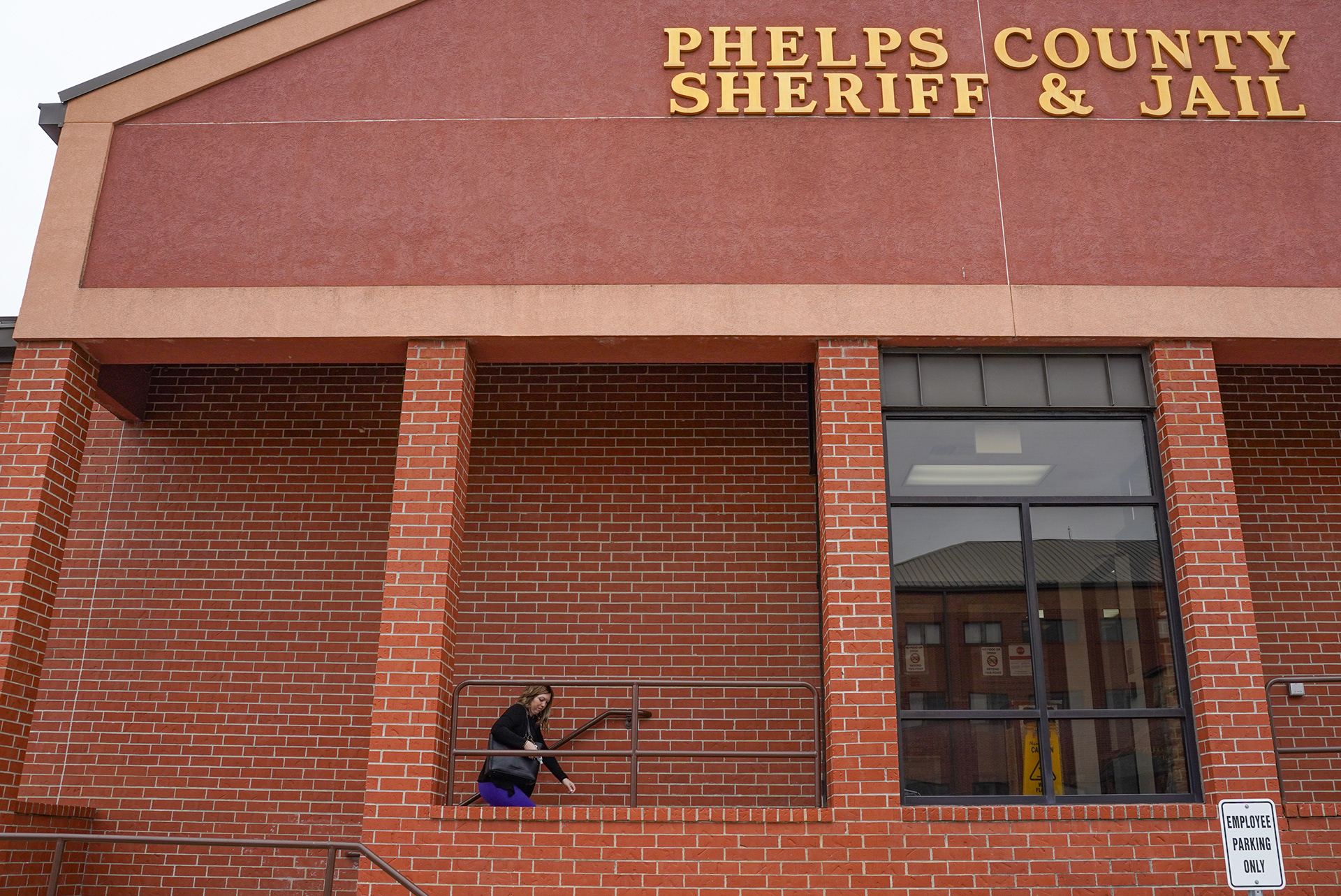 Rowe walks up the steps of the Phelps County Jail to visit incarcerated clients on Monday, March 31, 2025, in Rolla, Mo. Rowe’s attitude towards every conversation with a client is kind but serious, informative and uplifting, always expressing genuine care and confidence in the client no matter what their situation is.
