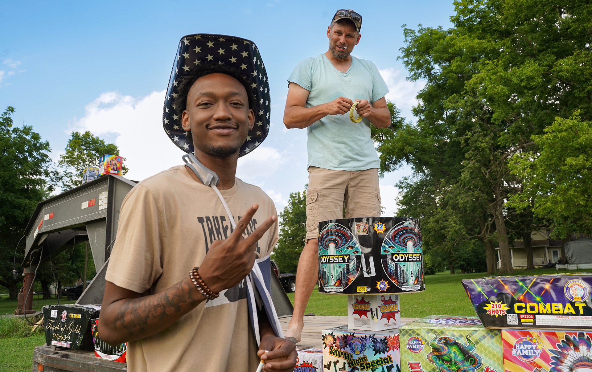 DeAnthony Johnson poses for a portrait while Jason Bivins prepares fireworks behind him on Friday, July 4, 2025, in Stotts City, Mo. Bivins is one of the leaders of the faith based recovery program Whosoever, including as a mentor to Johnson and others. Many gathered for the Independence Day celebration put on by the program, in an attempt to bring together locals and currently people in the program together. 